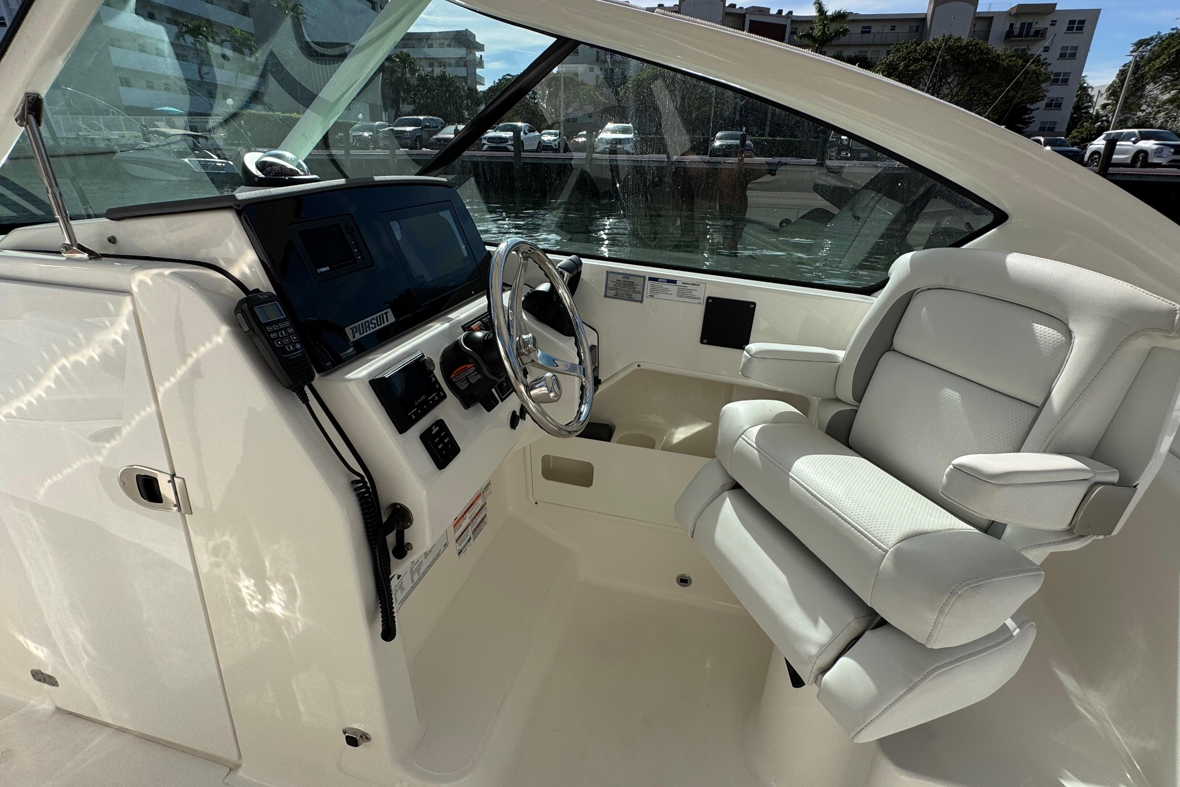 2022 Pursuit DC 266 Dual Console boat interior with steering wheel and captain's chair.