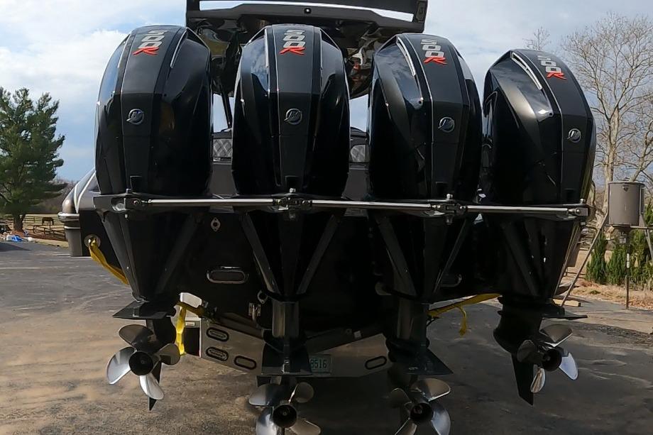 Four powerful outboard motors on a 2018 MTI V42 boat, parked outdoors.
