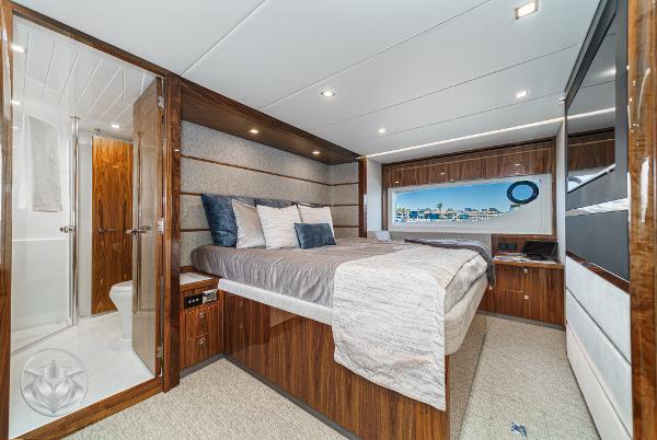Luxurious bedroom interior of 2025 Riviera 645 SUV yacht with modern amenities.