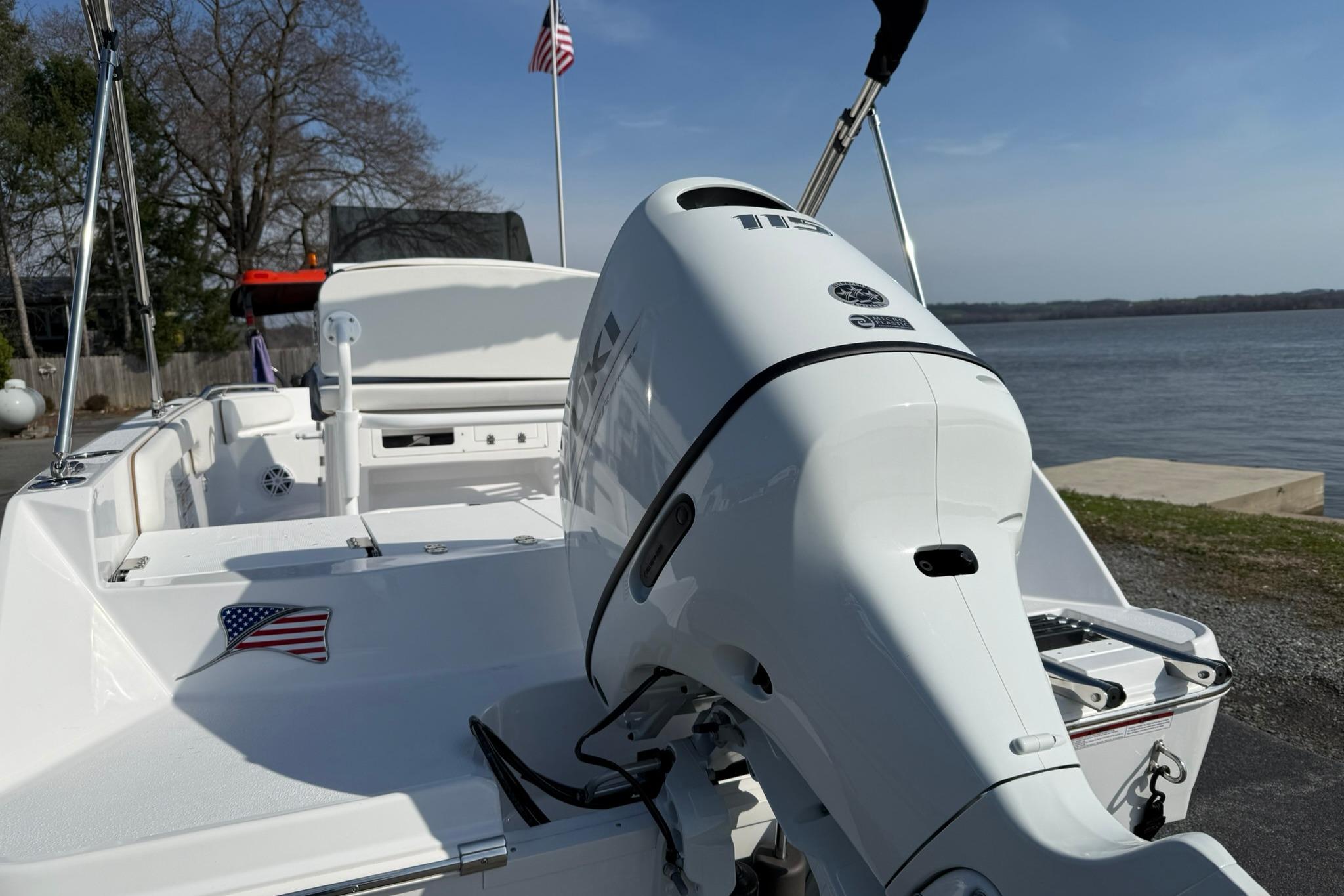 2026 Stingray 173 CC boat with outboard motor, docked by a serene lake.