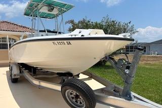 2008 Boston Whaler 230 Dauntless boat on trailer, parked in driveway.