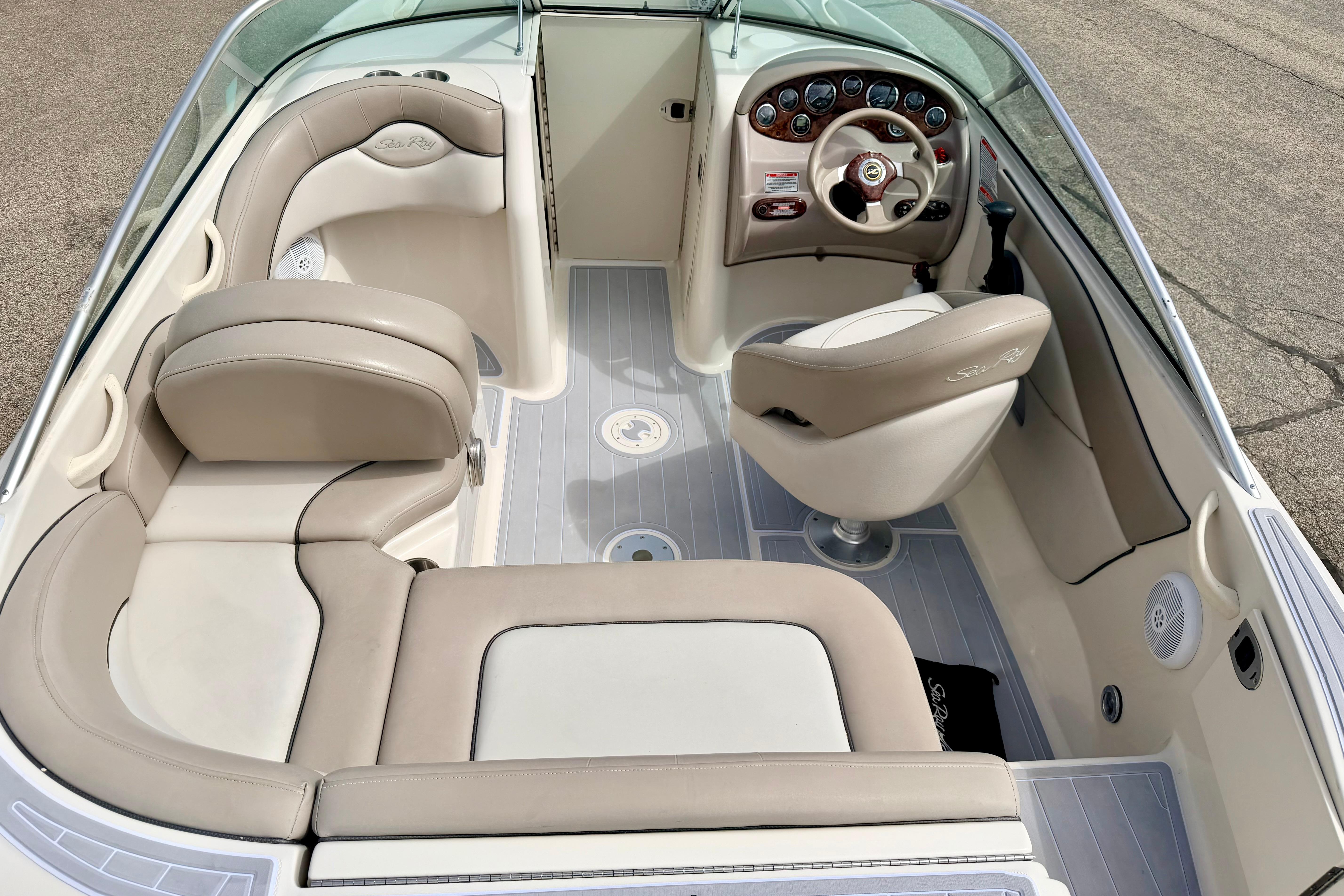 Interior view of a 2003 Sea Ray 200 Sundeck boat with beige seating and dashboard.