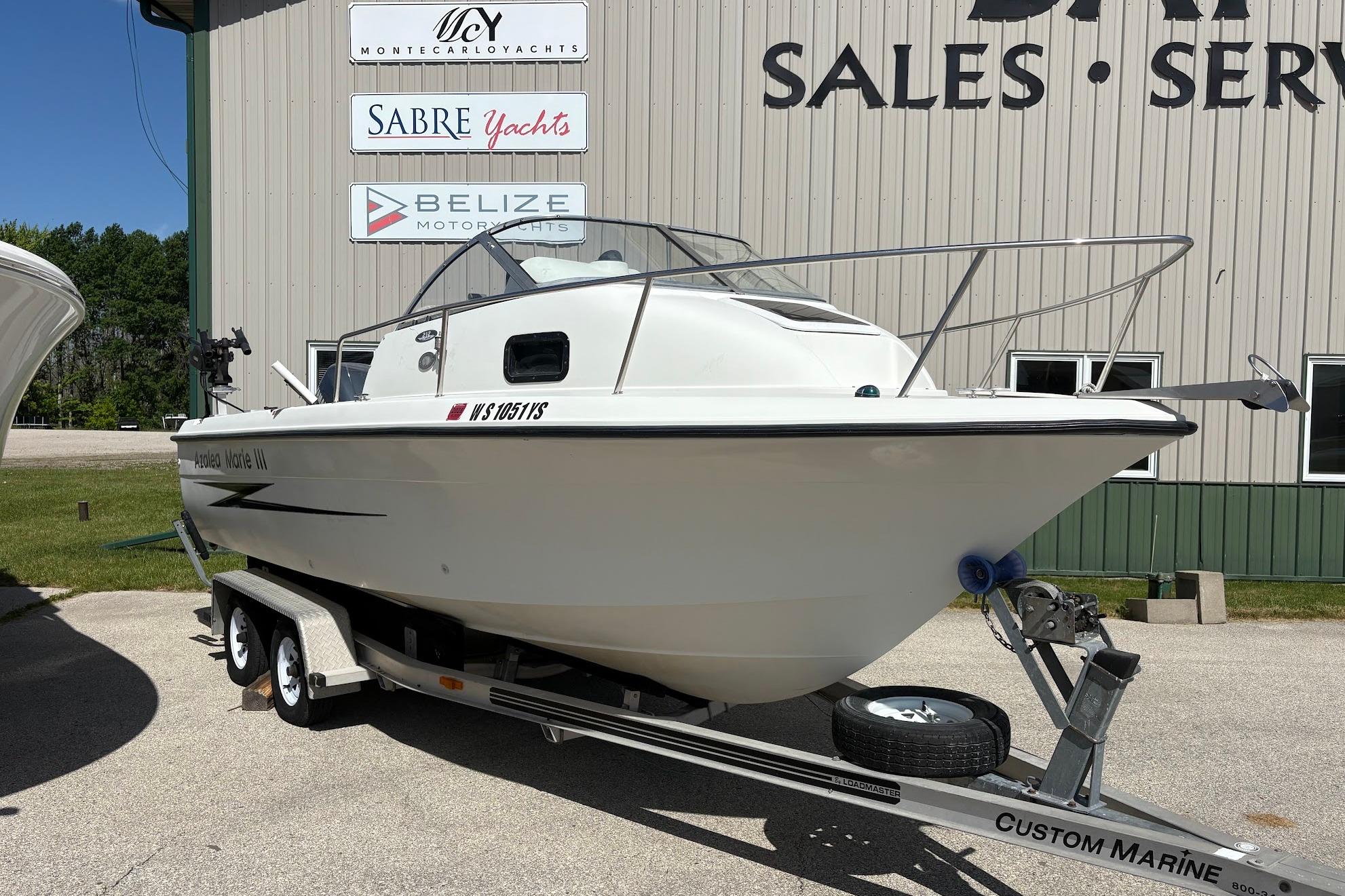 2002 Hydra-Sports 212 WA boat on trailer outside marine sales and service building.