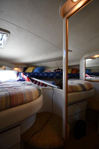 Interior cabin of a 1997 Sea Ray 400 Sundancer yacht with cozy bedding.