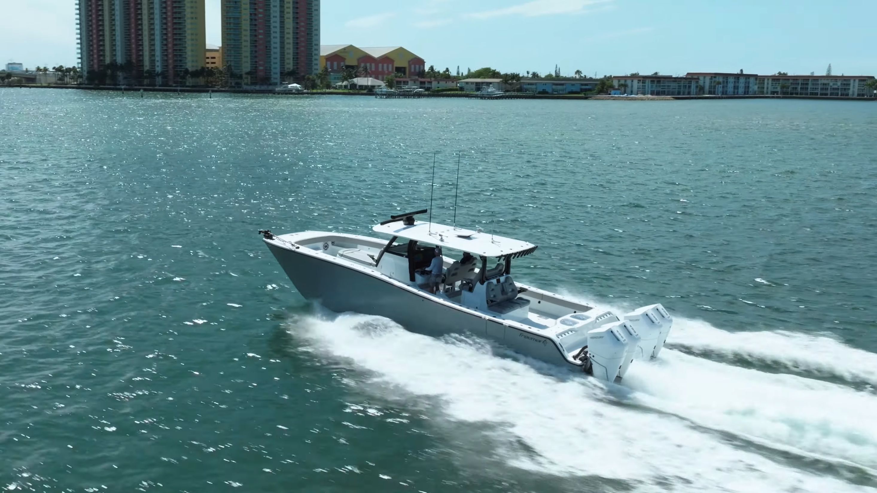 Freeman 43 boat 2024 cruising on water near high-rise buildings.