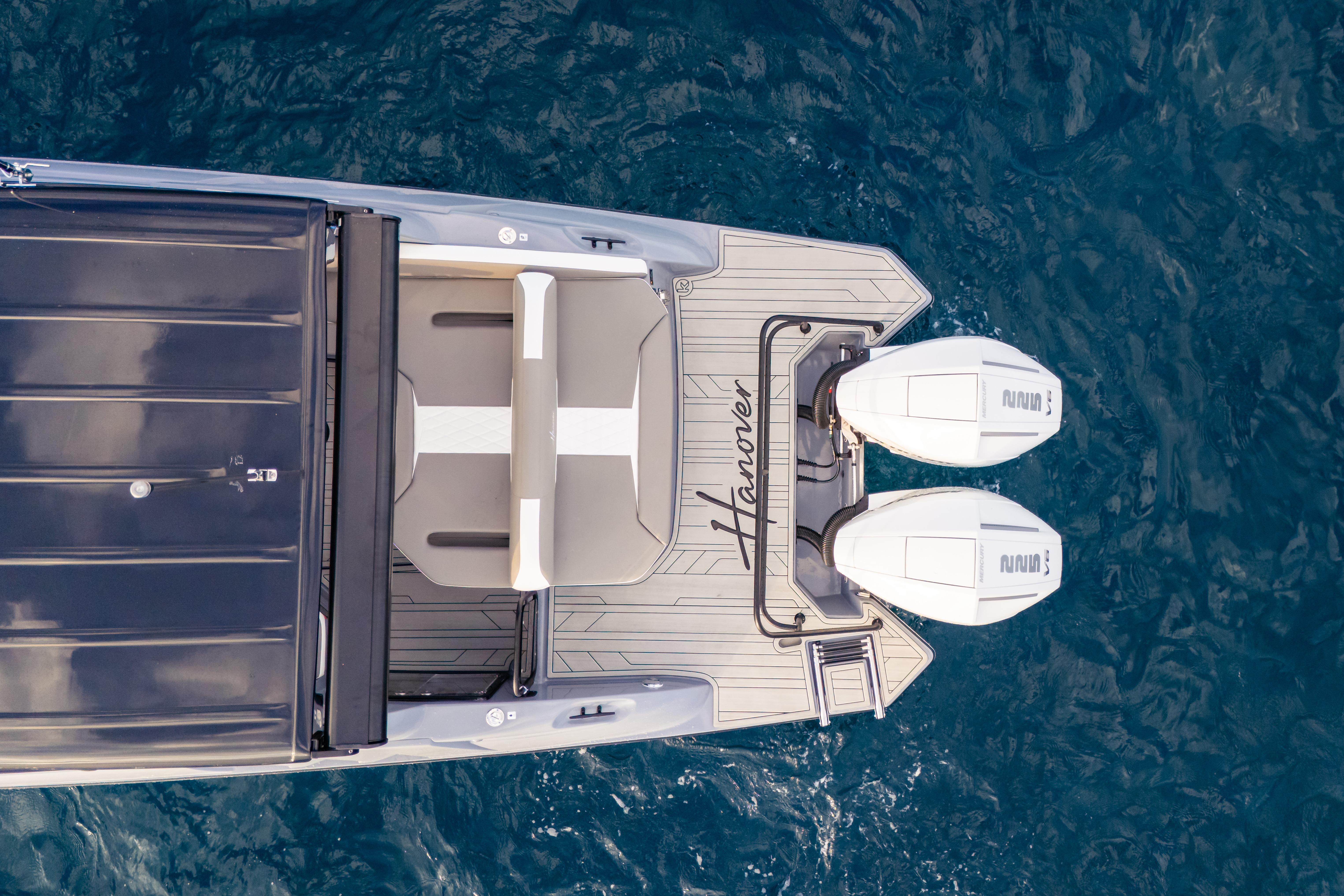 Top view of a 2026 Hanover 305 boat with dual engines on blue water.