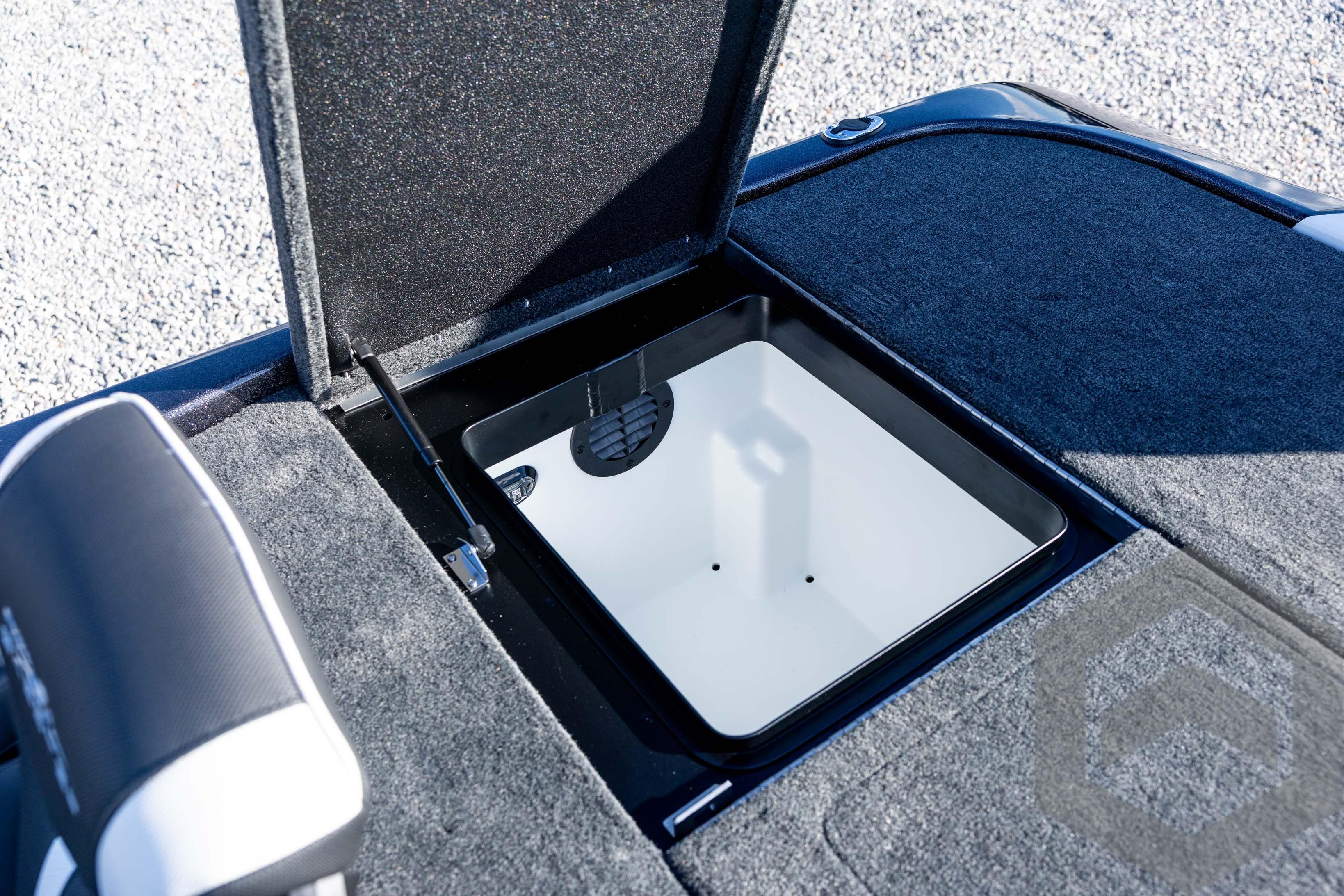 Open storage compartment in 2026 Skeeter ZXE20 boat, featuring carpeted interior.