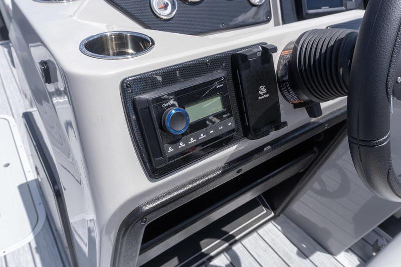 Dashboard of 2026 SunCatcher Select 322SL boat with stereo system and steering wheel.