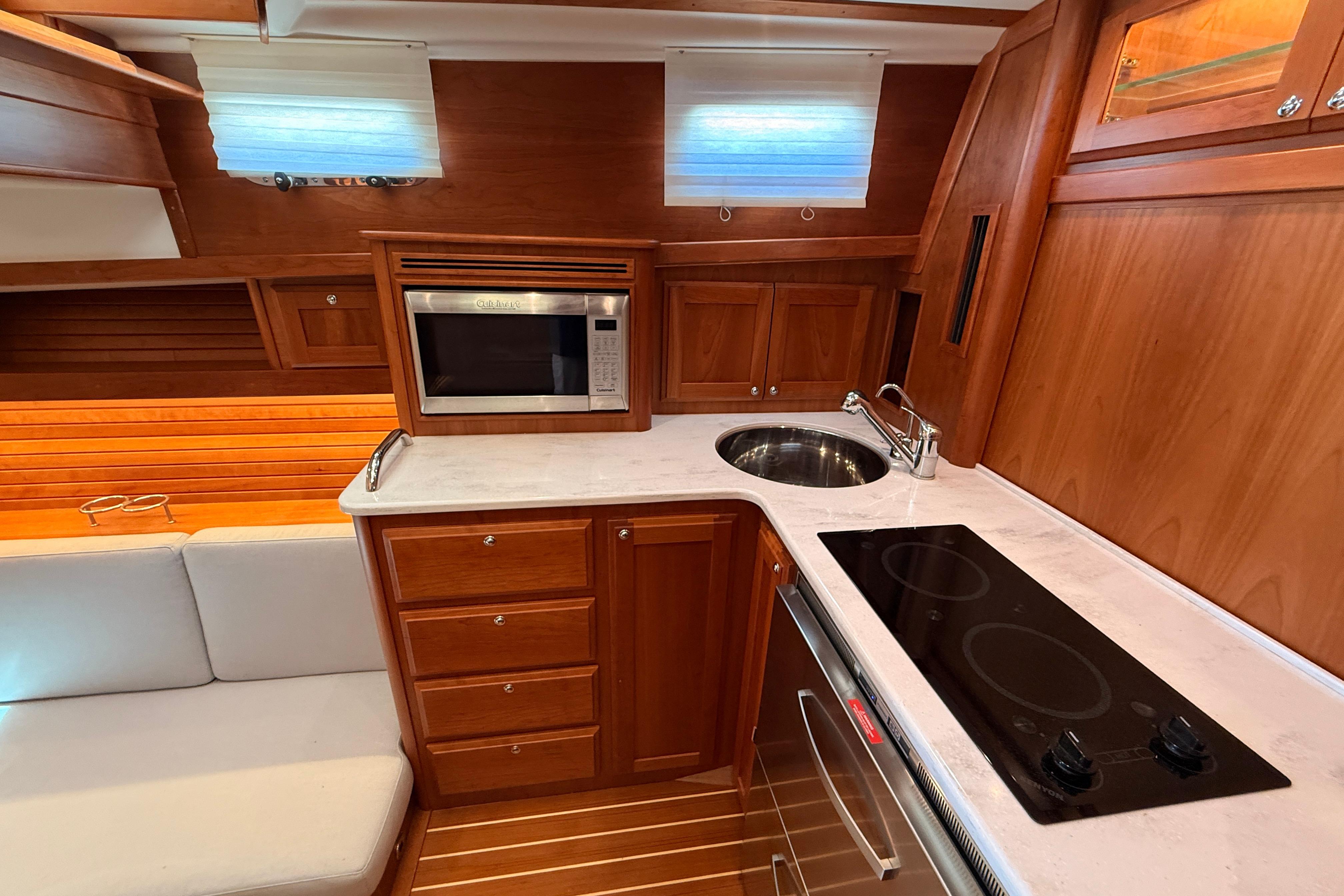 Luxurious 2022 Sabre 38 Salon Express galley with wood cabinetry and modern appliances.