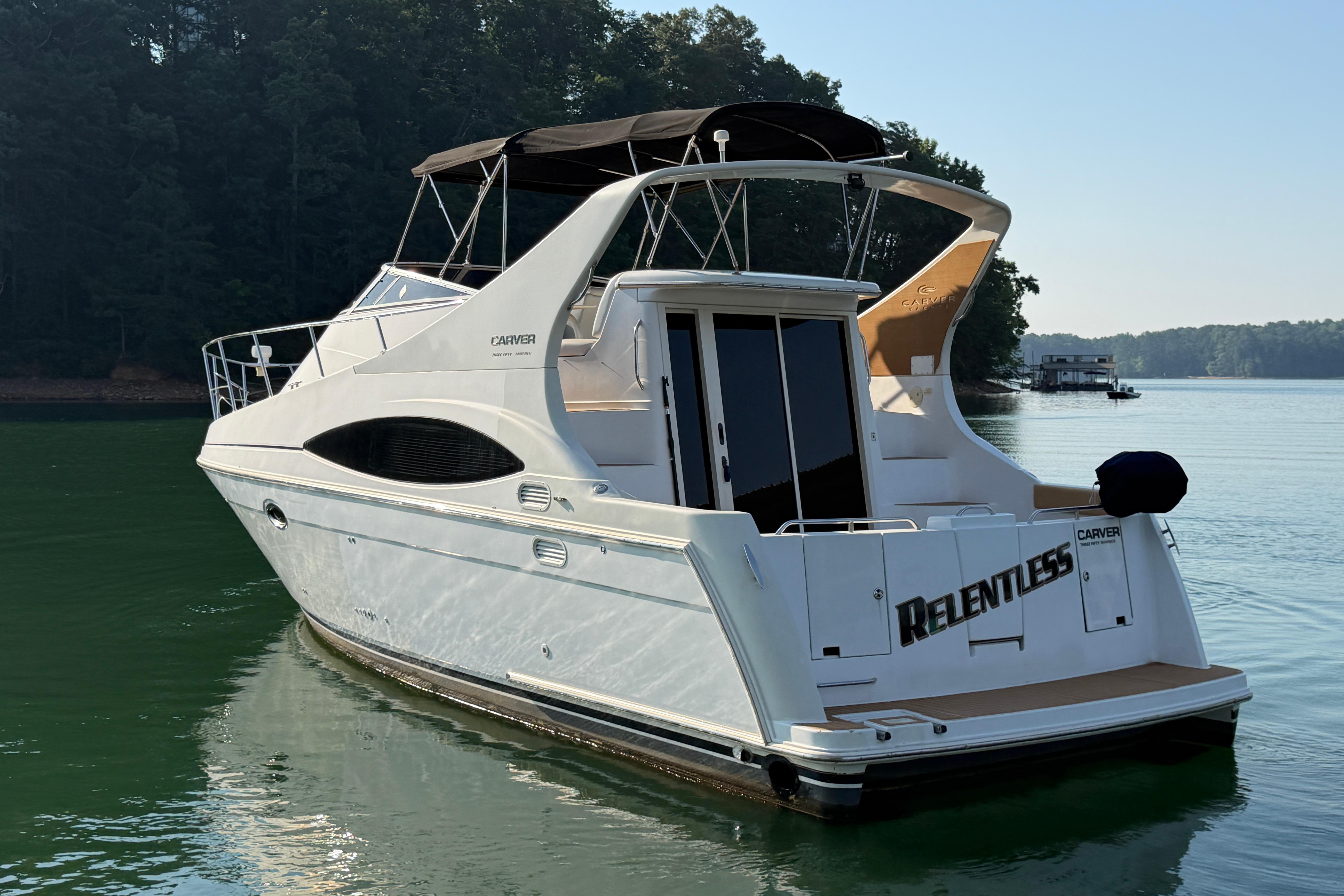 2003 Carver 350 Mariner yacht named "Relentless" on serene lake waters.