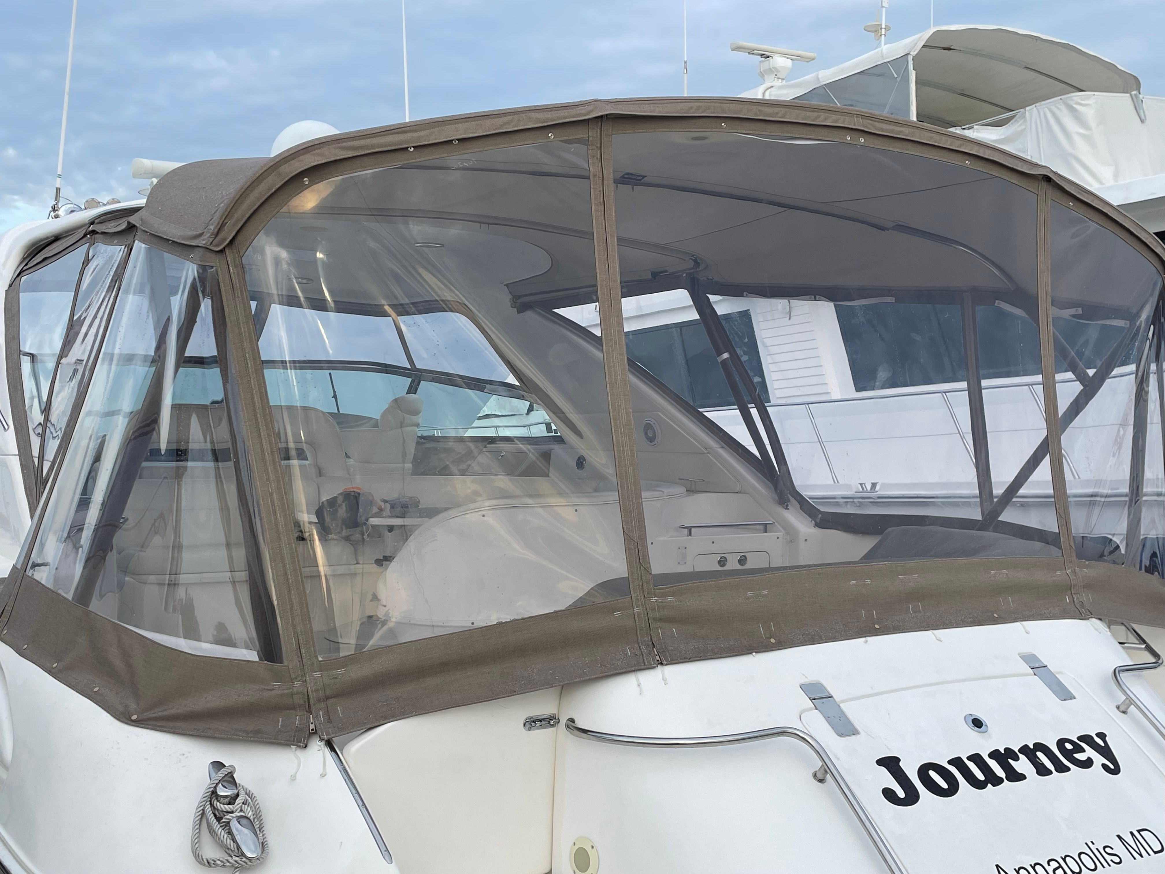 A 2003 Sea Ray S600 Sunsport with an enclosed cabin at the dock.