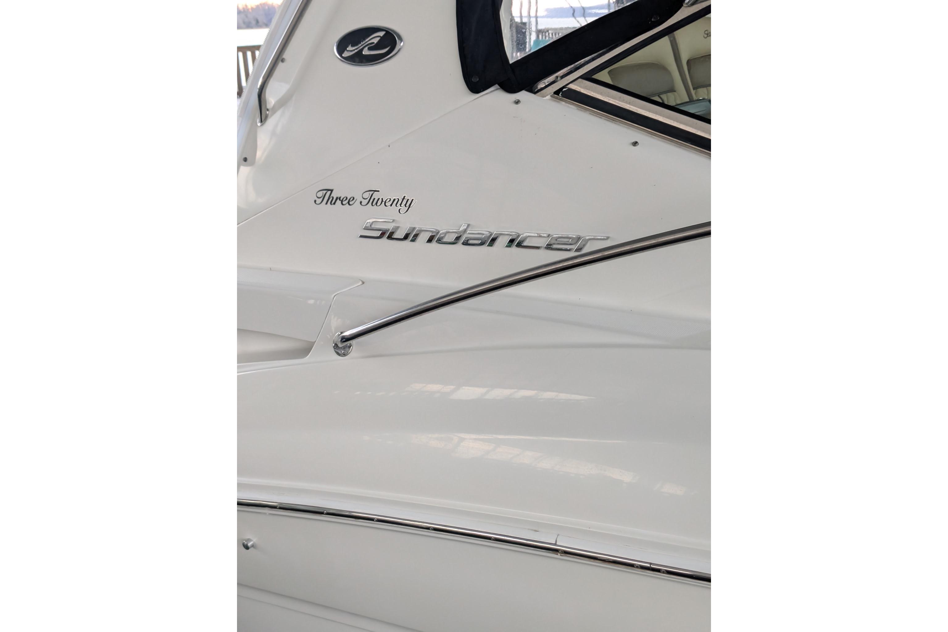 2002 Sea Ray Sundancer 320 boat side view with model name and logo.