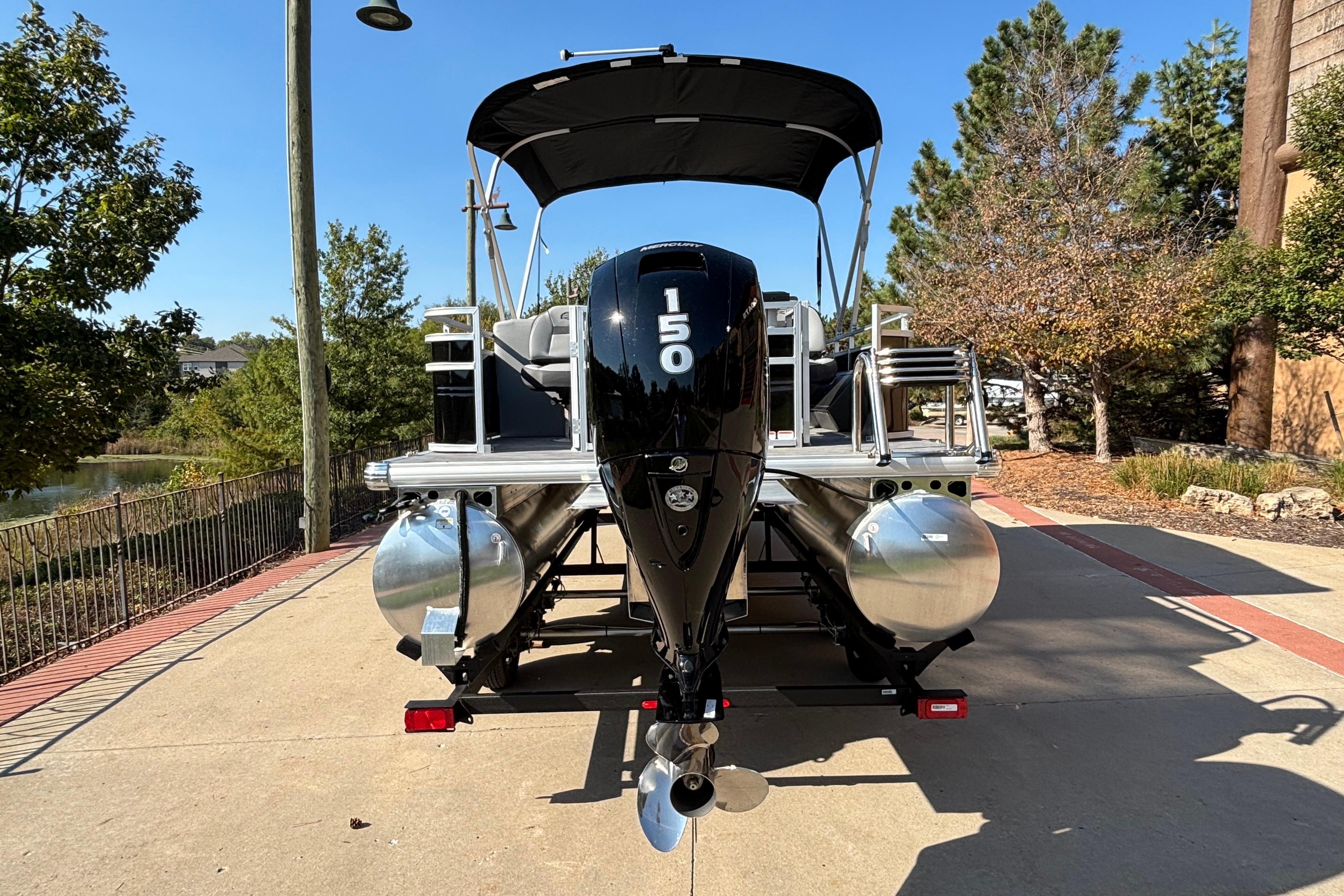 2026 Sun Tracker SportFish 22 DLX pontoon boat with powerful outboard motor.