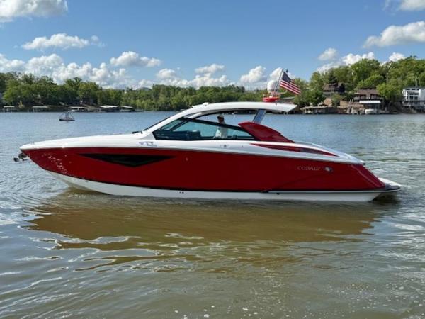 2022 Cobalt A36BR boat on a lake, red and white design, clear sky background.