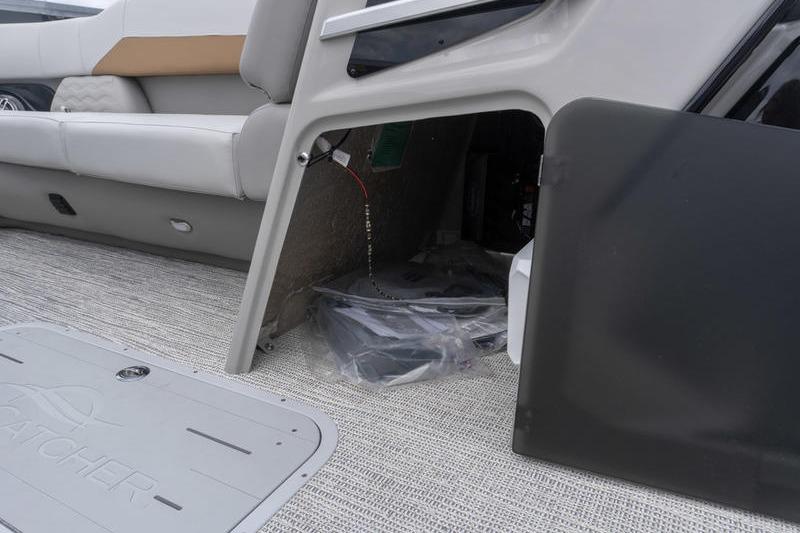 Interior view of 2026 SunCatcher Elite 326 SS boat, showcasing seating and storage area.