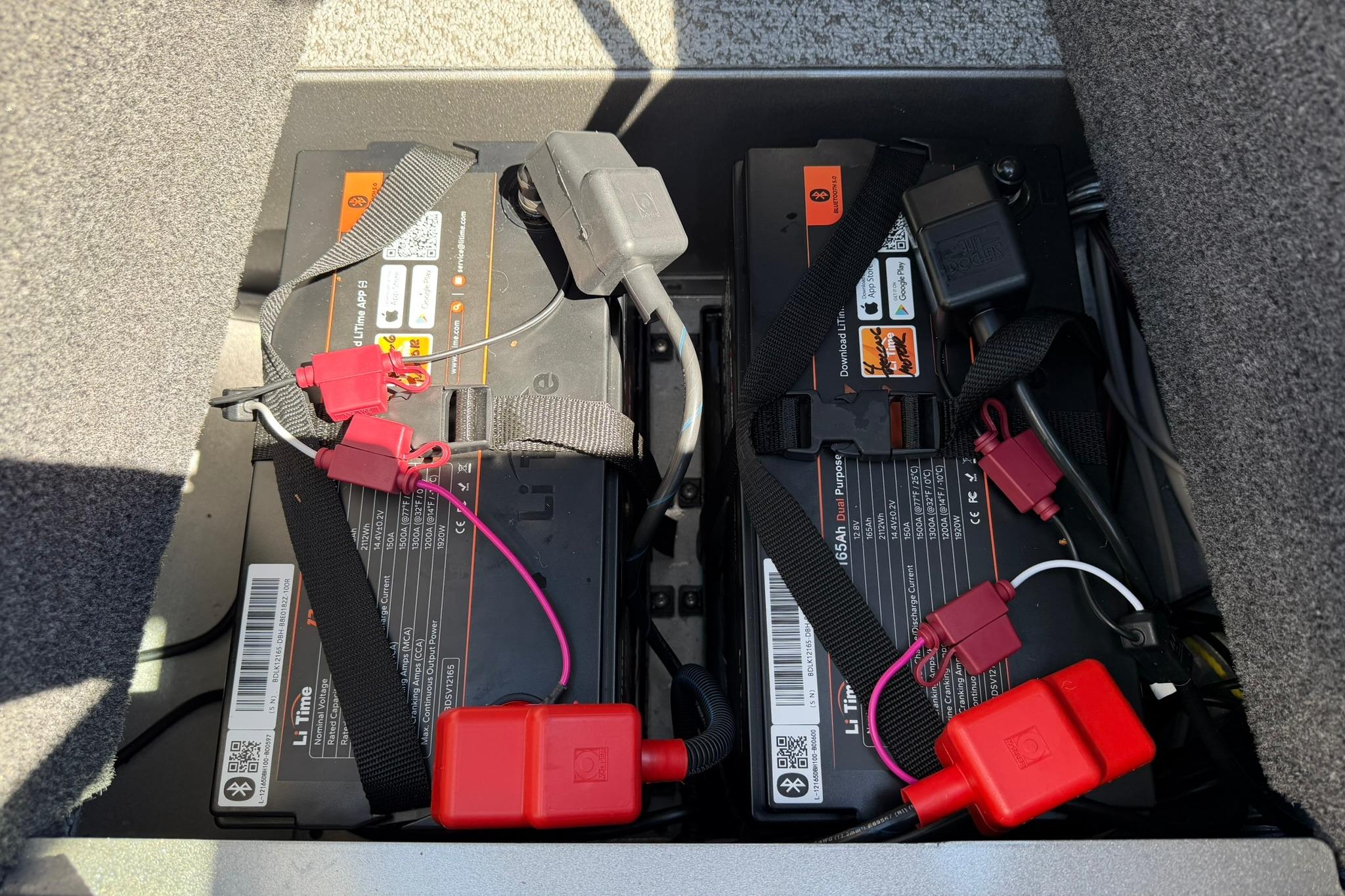 2024 Lund 1875 Impact XS Sport boat batteries with secure straps and wiring connections.