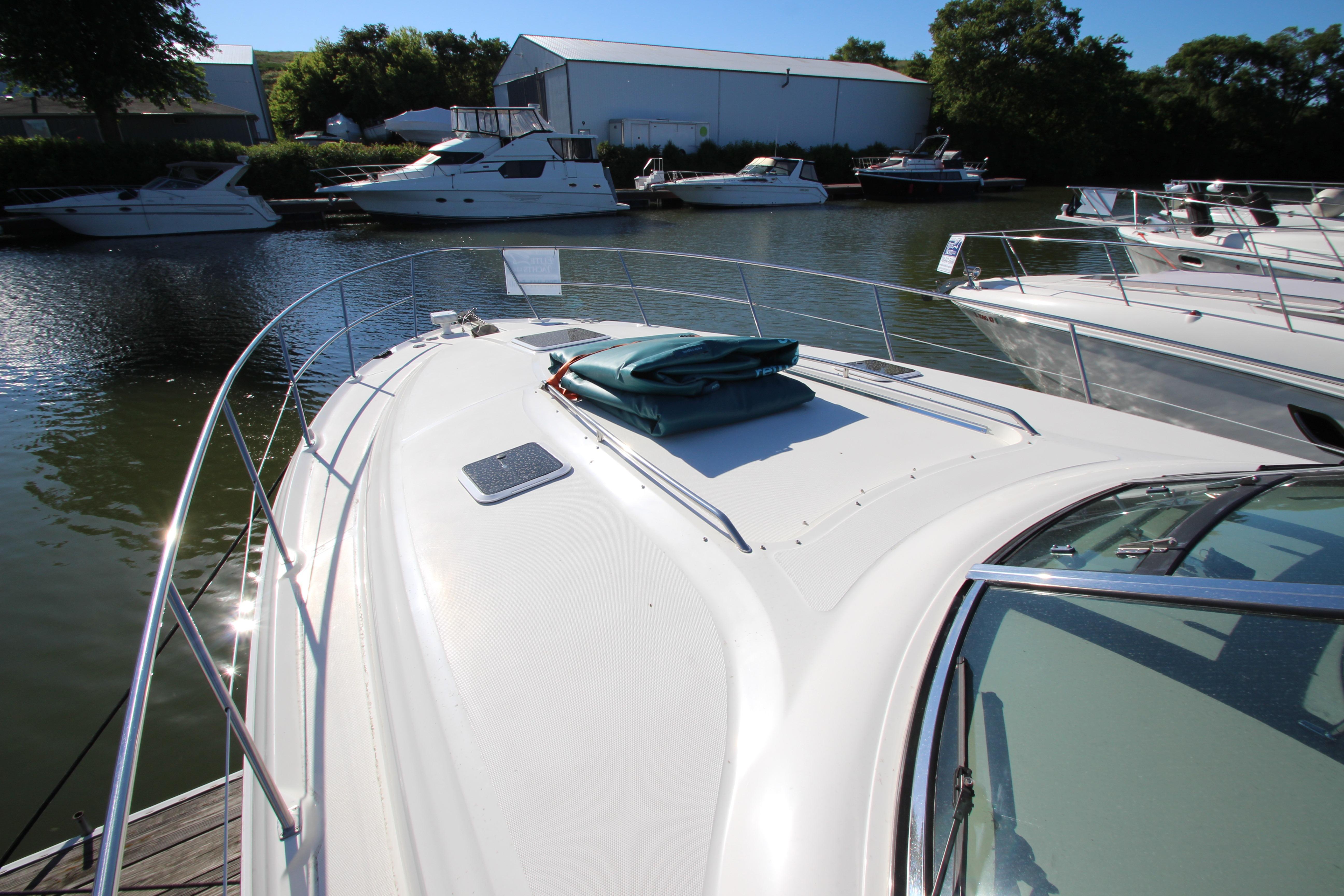 2000 Sea Ray 410 Express Cruiser docked in a marina, surrounded by other boats.