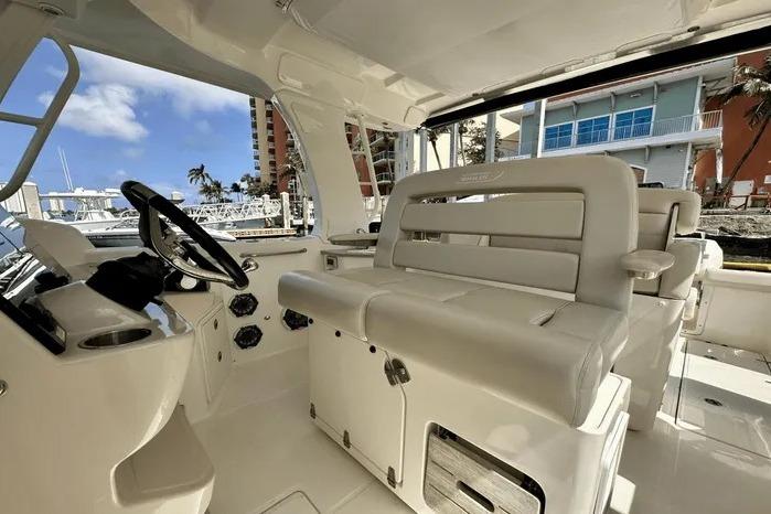 2019 Boston Whaler 350 Realm interior with helm and seating, dockside view.