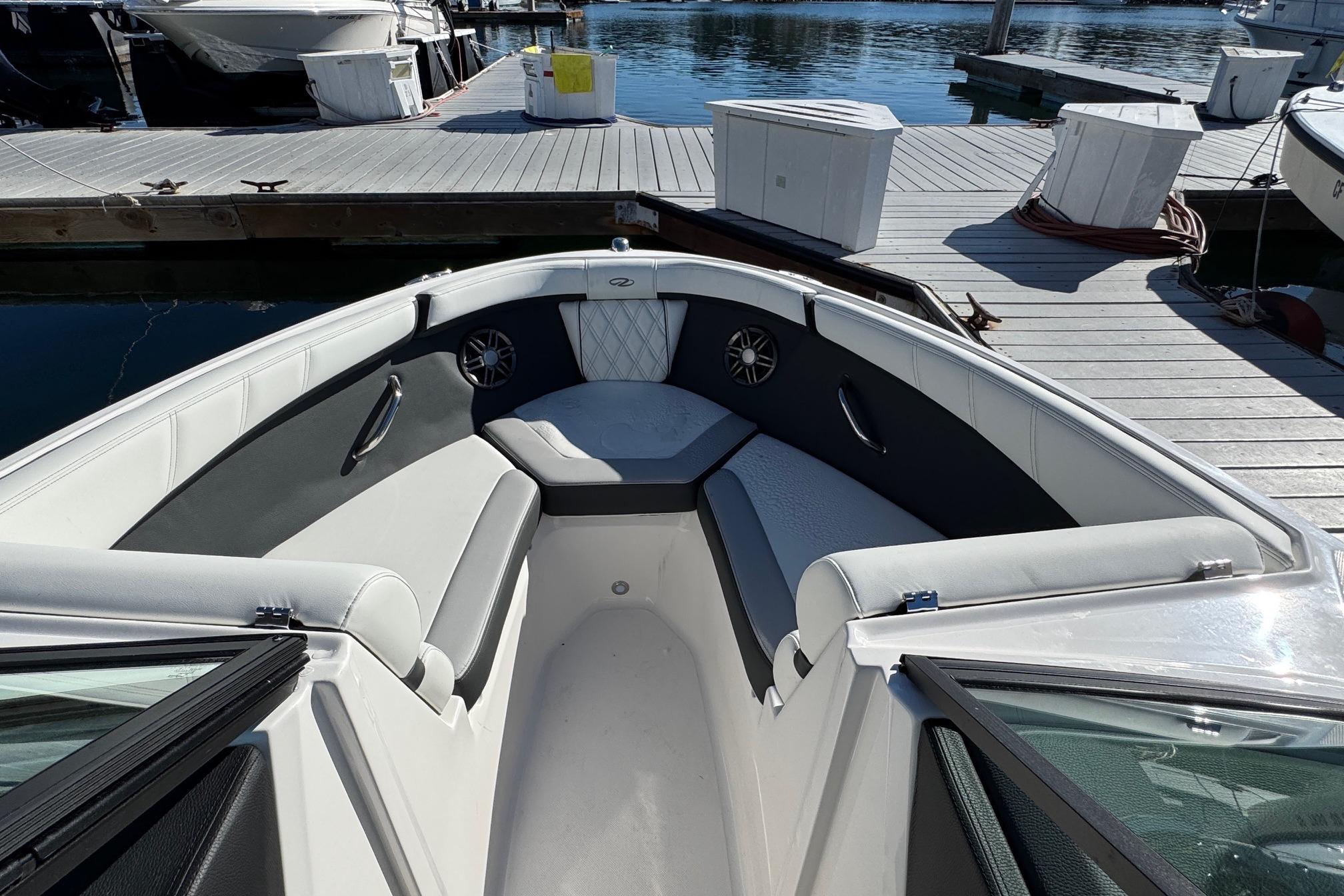 2026 Regal 21 OBX boat interior with cushioned seating, docked at marina.