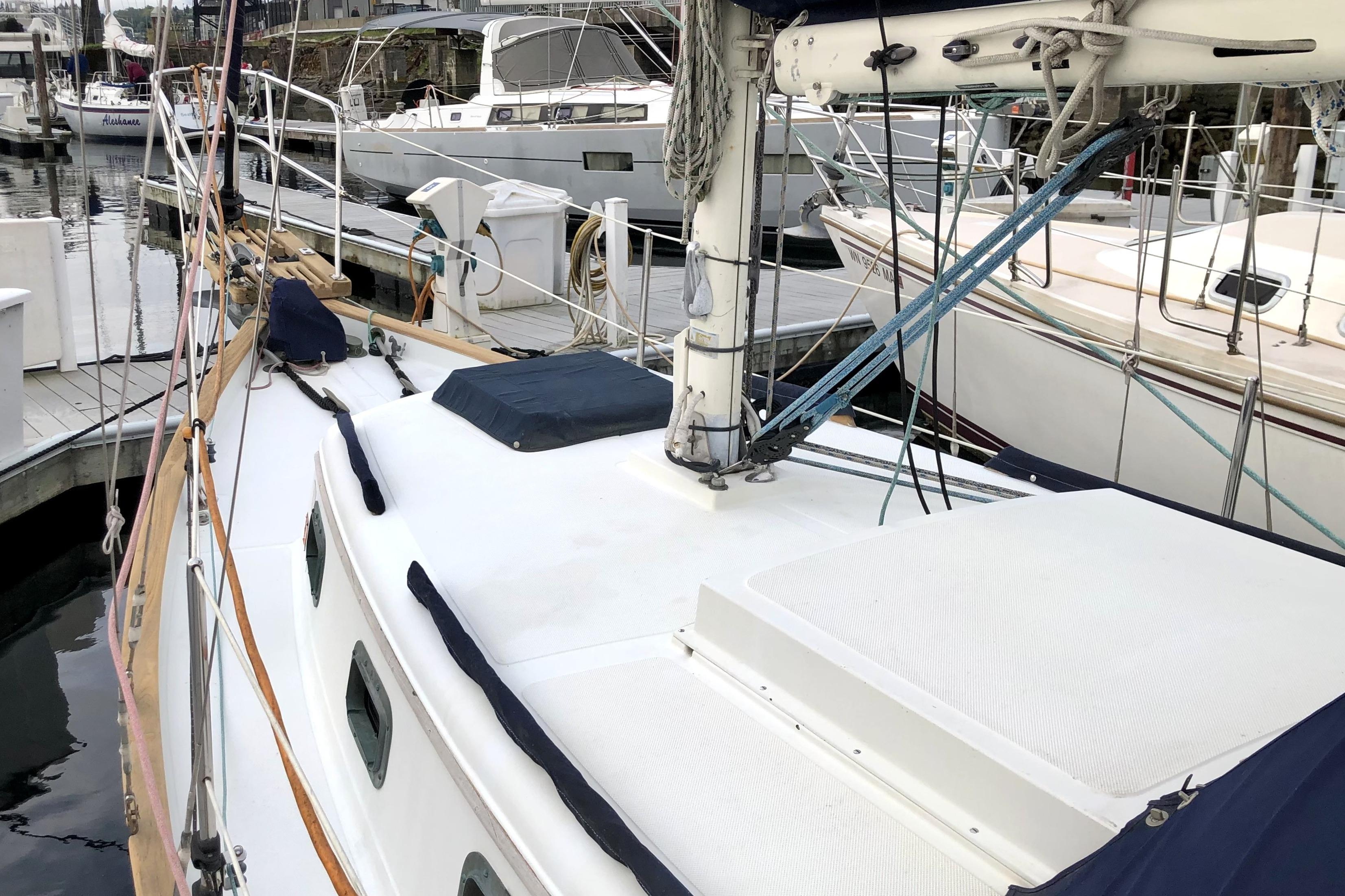 1989 Pacific Seacraft Dana 24 sailboat docked at a marina, showcasing deck and rigging.