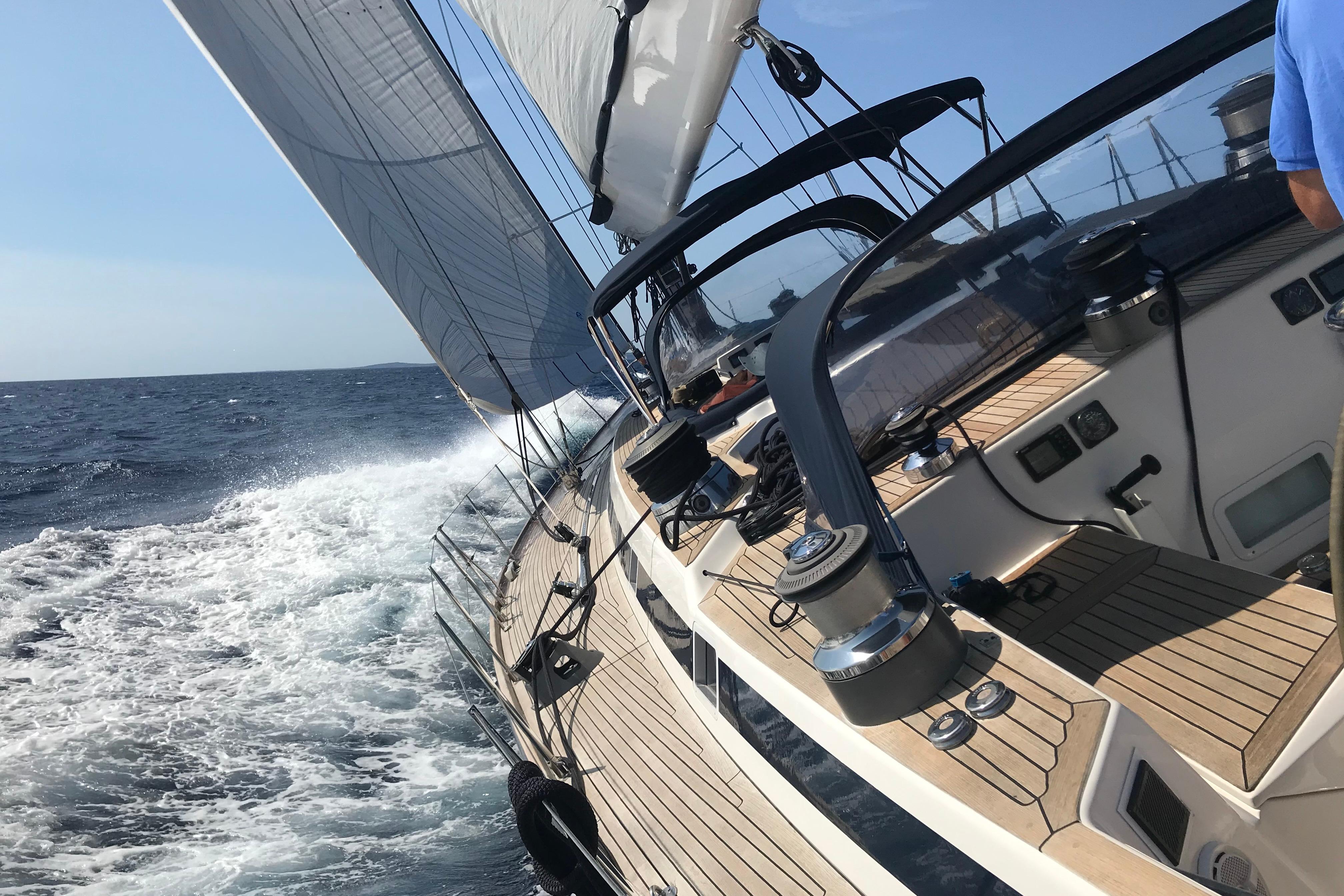 Sailing on a 2003 Nautor Swan 77 yacht, cutting through ocean waves.