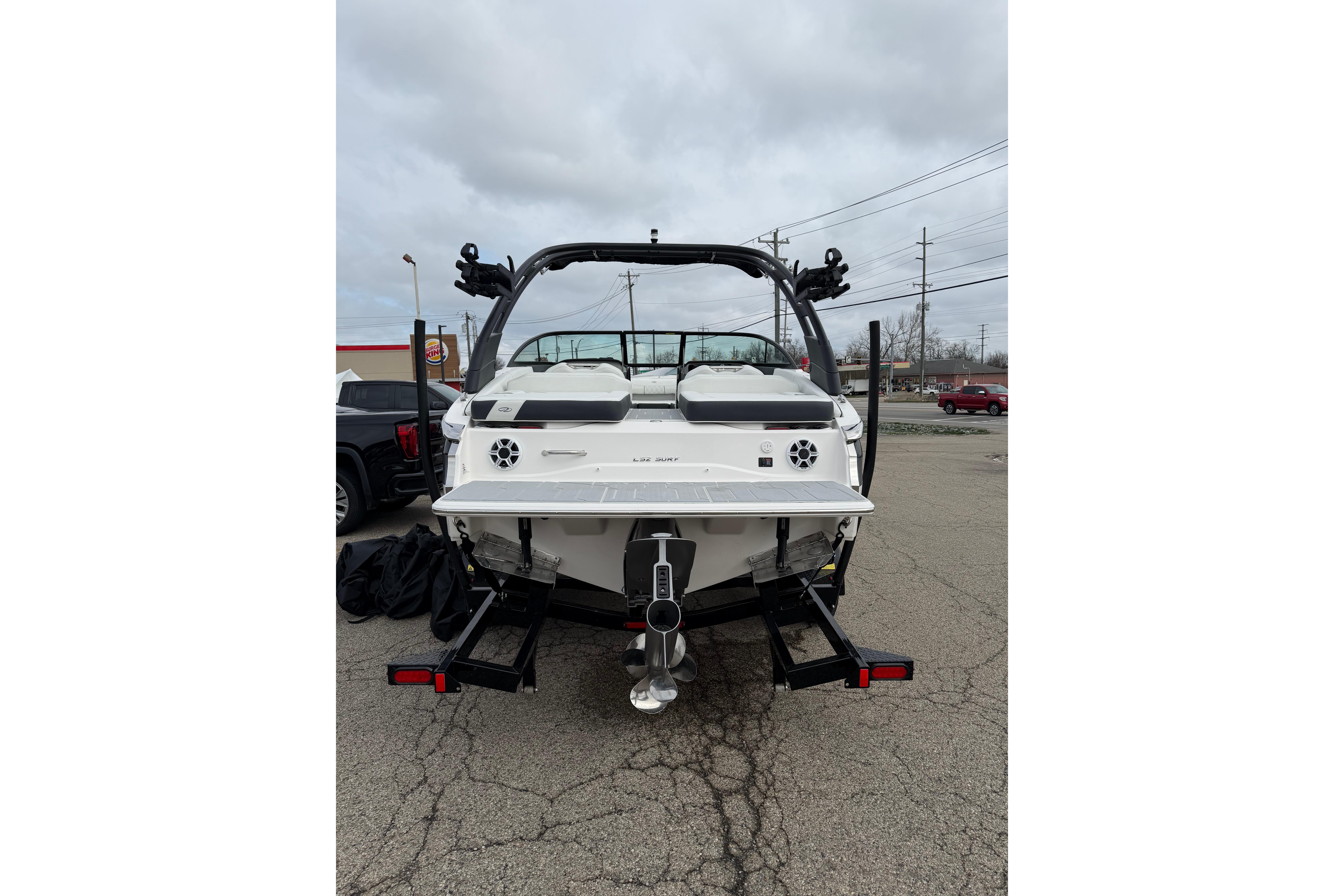 2026 Regal LS2 Surf boat rear view in parking lot, showcasing sleek design and features.