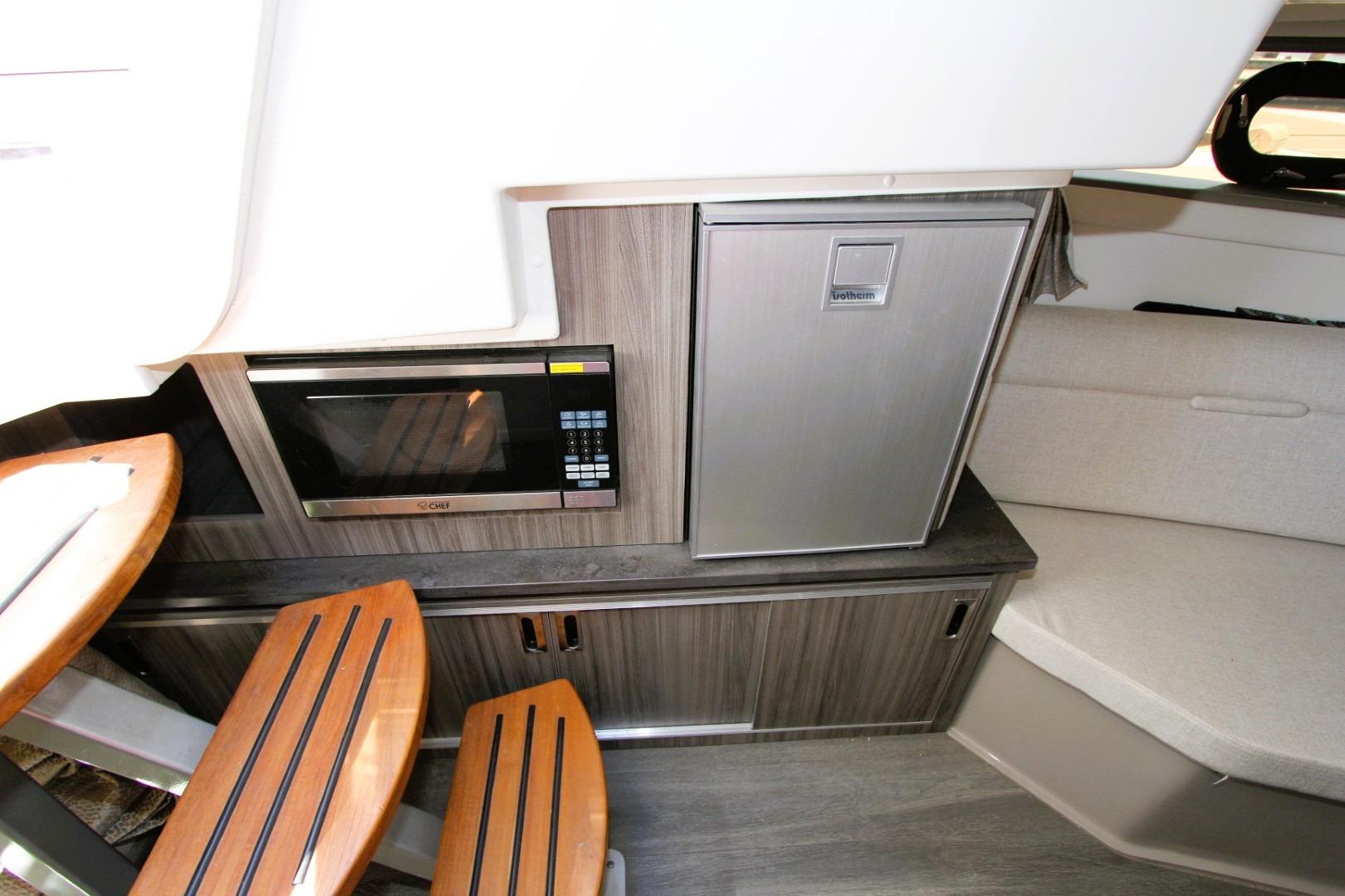 Interior of 2021 Sea Ray Sundancer 320 Outboard with microwave and compact fridge.