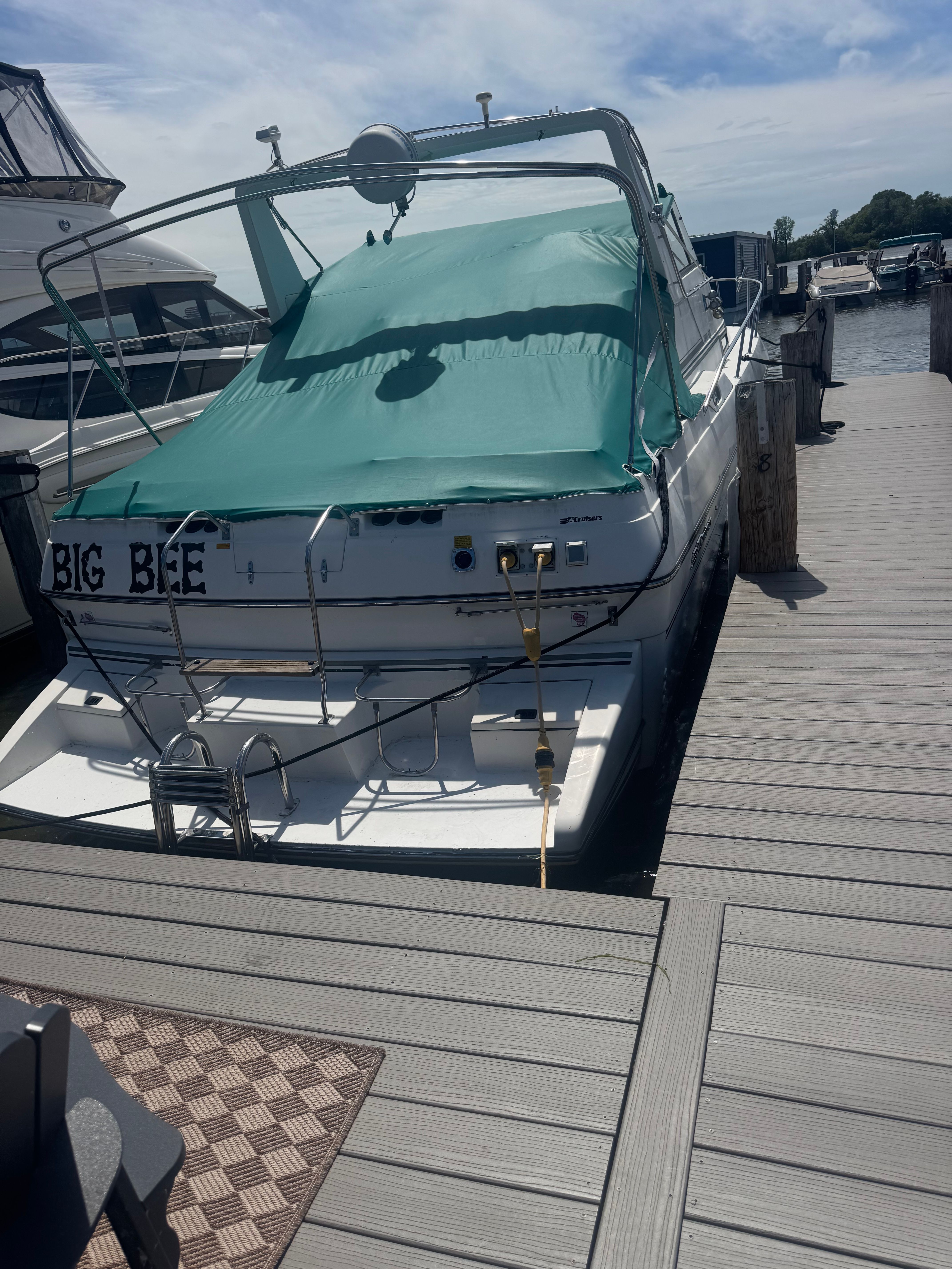 A 1992 Cruisers Yachts Esprit 3370 docked, featuring a green cover.