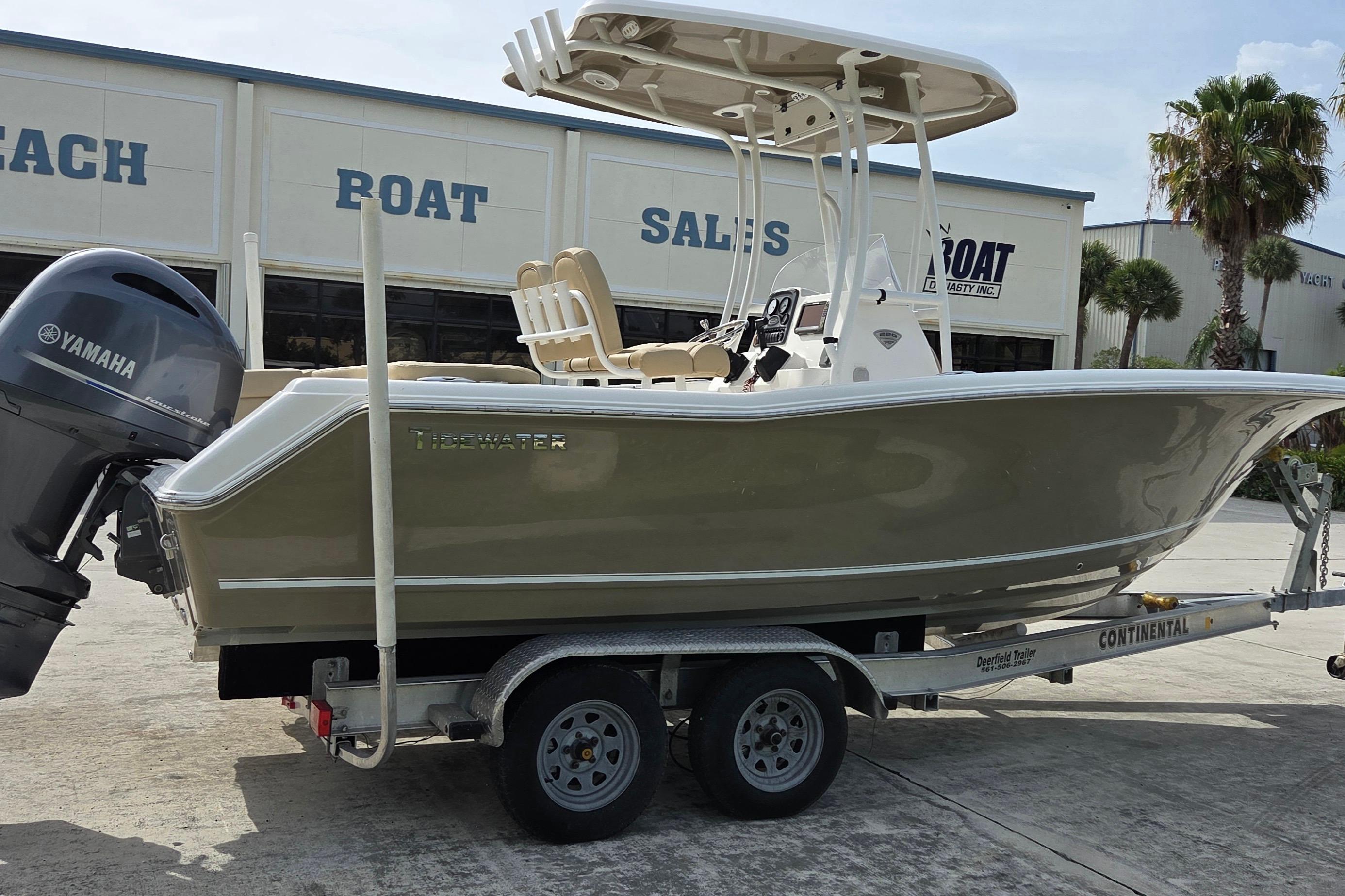 2015 Tidewater 220 LXF boat on trailer, featuring Yamaha outboard motor, parked outside sales building.