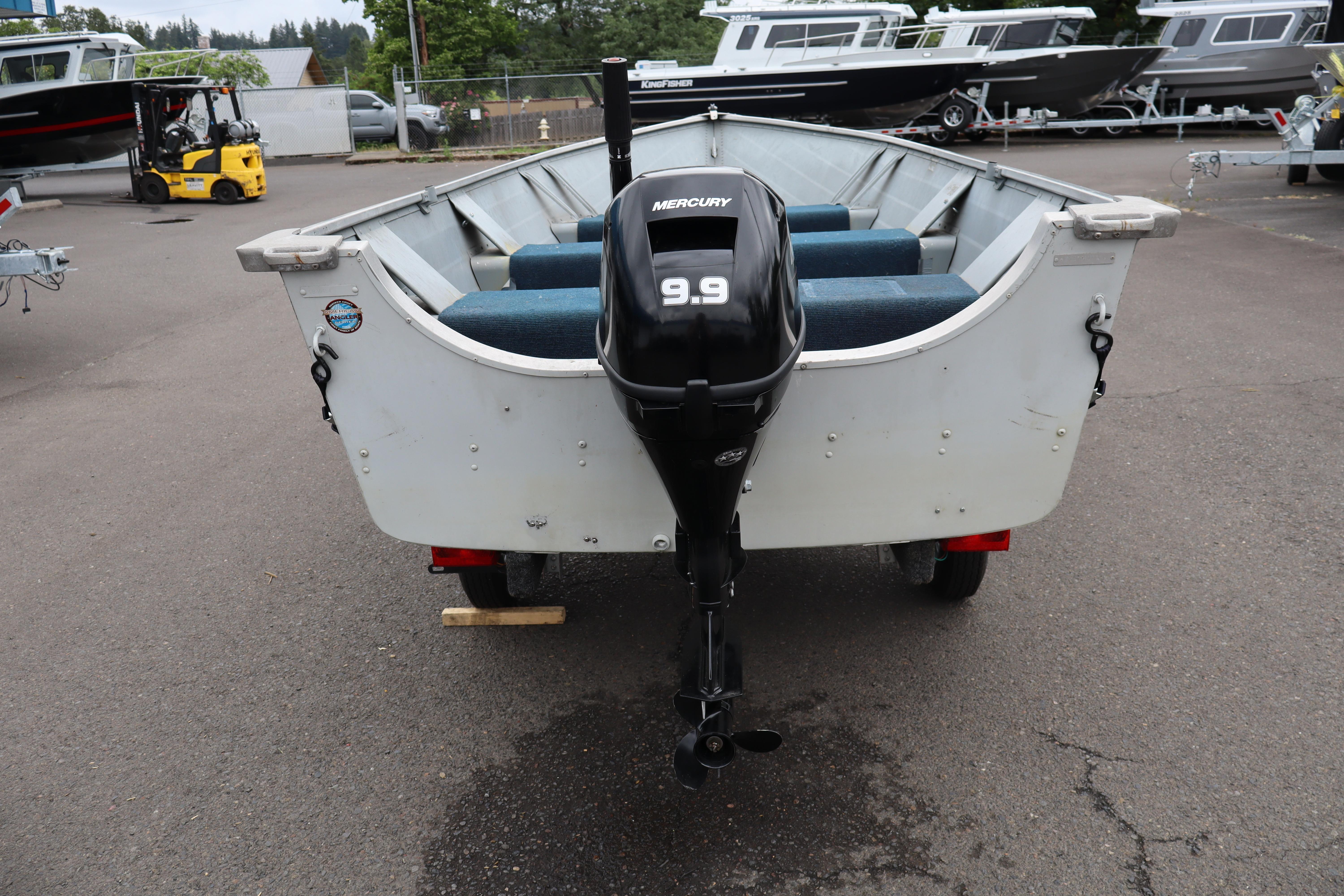 2003 Smoker Craft Alaskan 13 boat with Mercury 9.9 motor, parked outdoors.