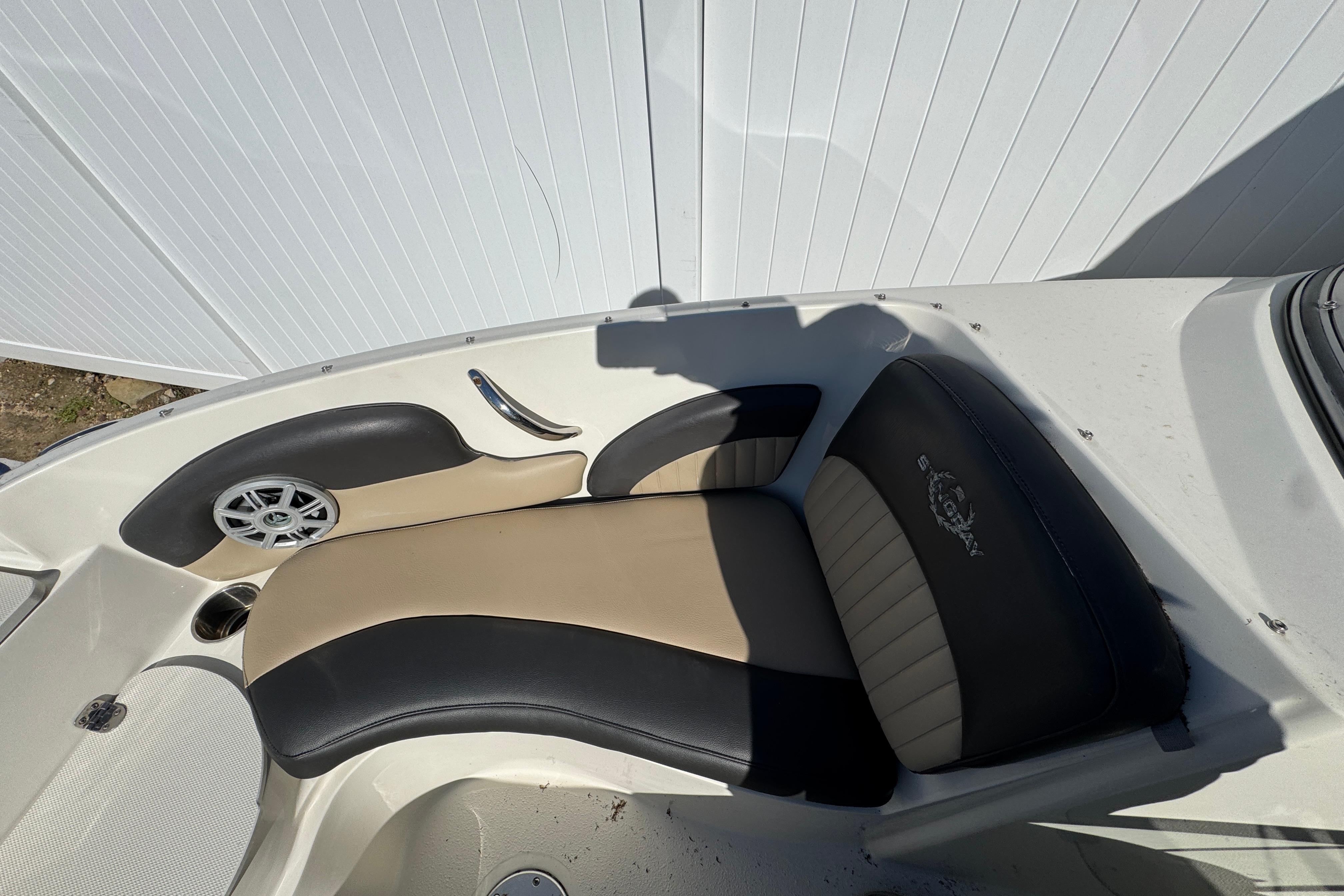 2018 Stingray 204 LR boat interior with beige and black seating, speaker, and cup holder.