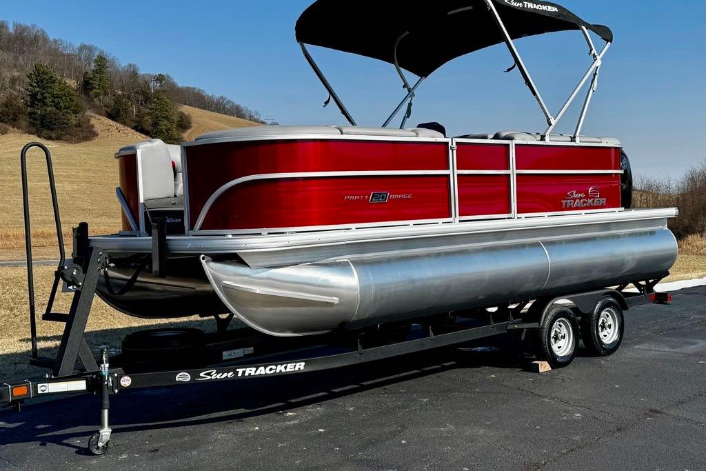 2026 Sun Tracker Party Barge 20 DLX pontoon boat on trailer, scenic background.