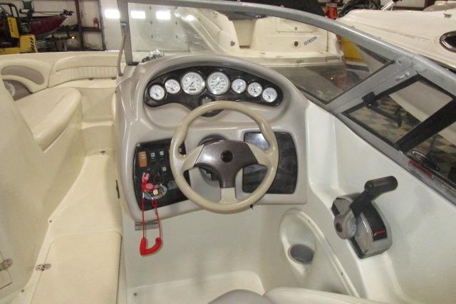 2004 Stingray 240 LR boat interior with steering wheel and dashboard controls.
