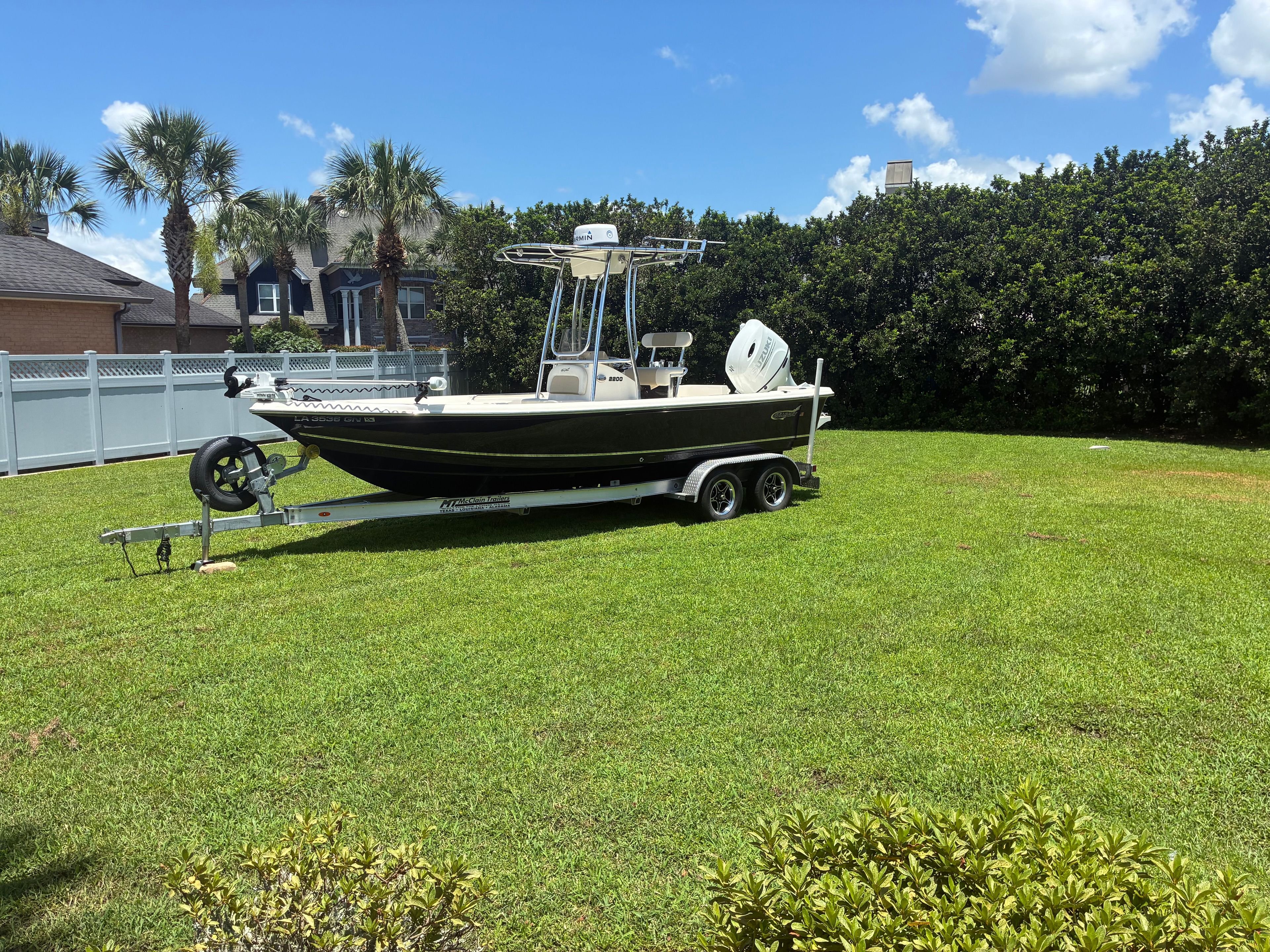A 2022 Bulls Bay 2200 boat on a trailer sits on a grassy lawn.