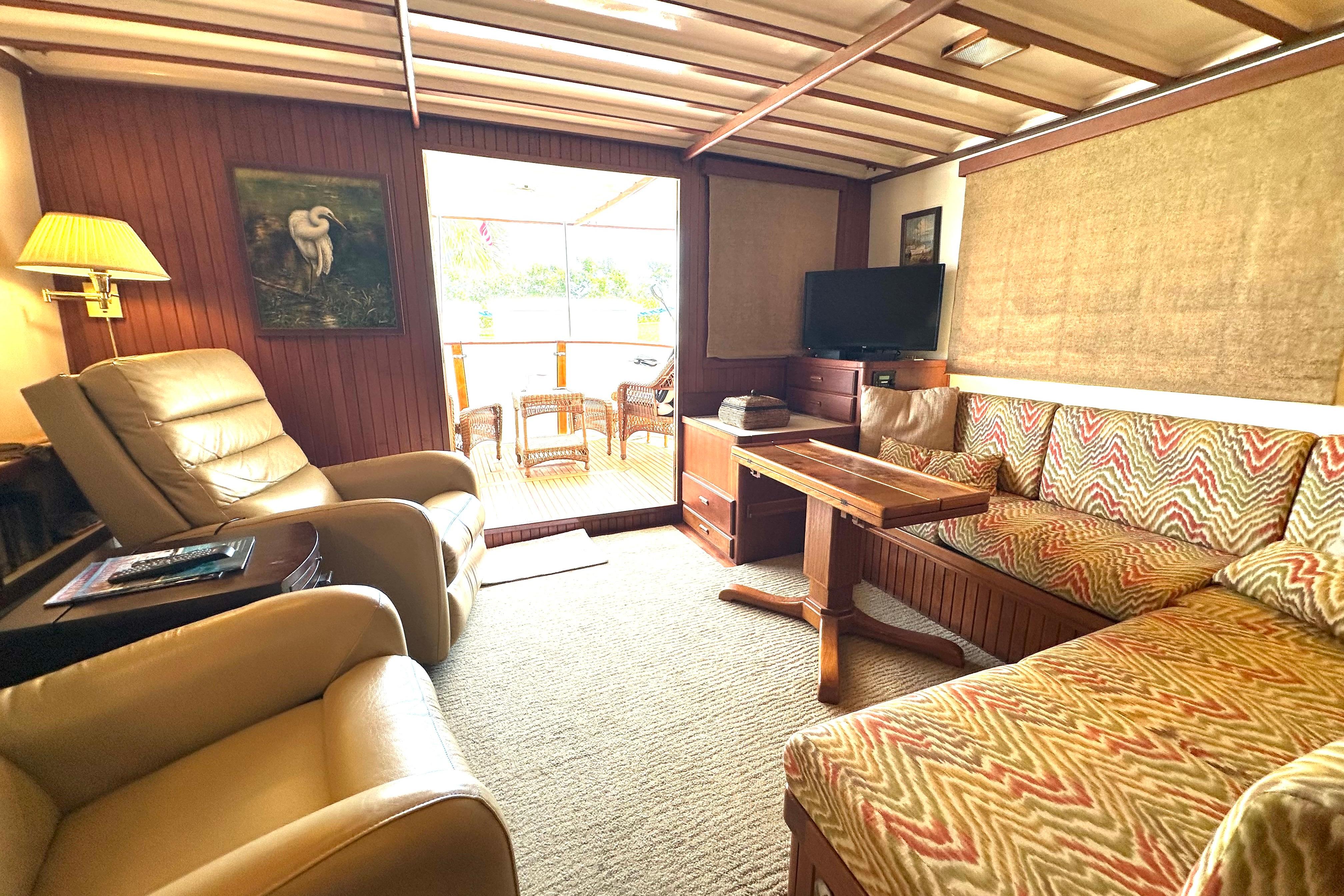 Cozy interior of 1987 Kadey-Krogen Manatee 36 with seating, TV, and natural light.