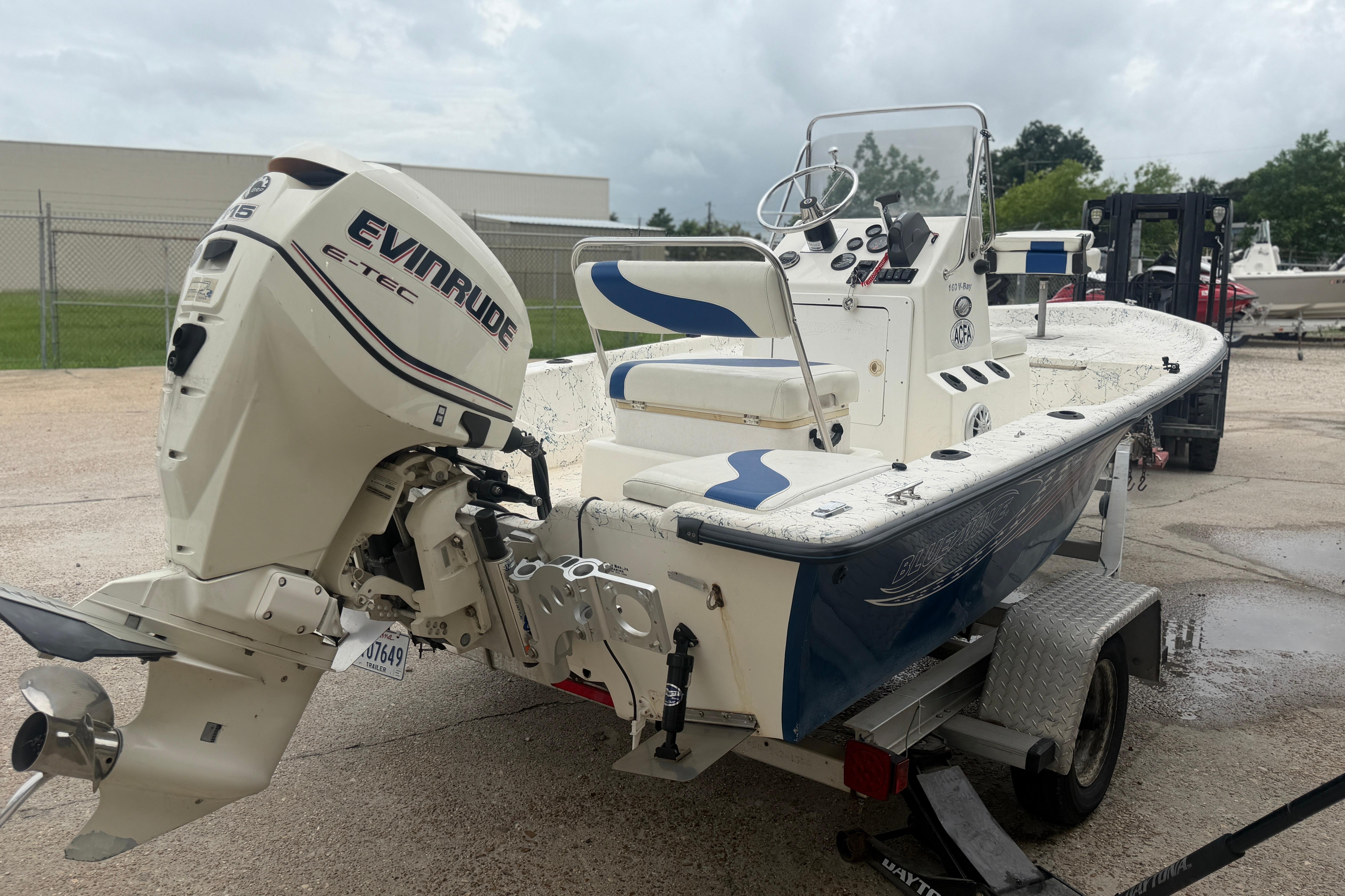 2004 Blue Wave 160 V-Bay boat with Evinrude E-TEC engine on trailer.