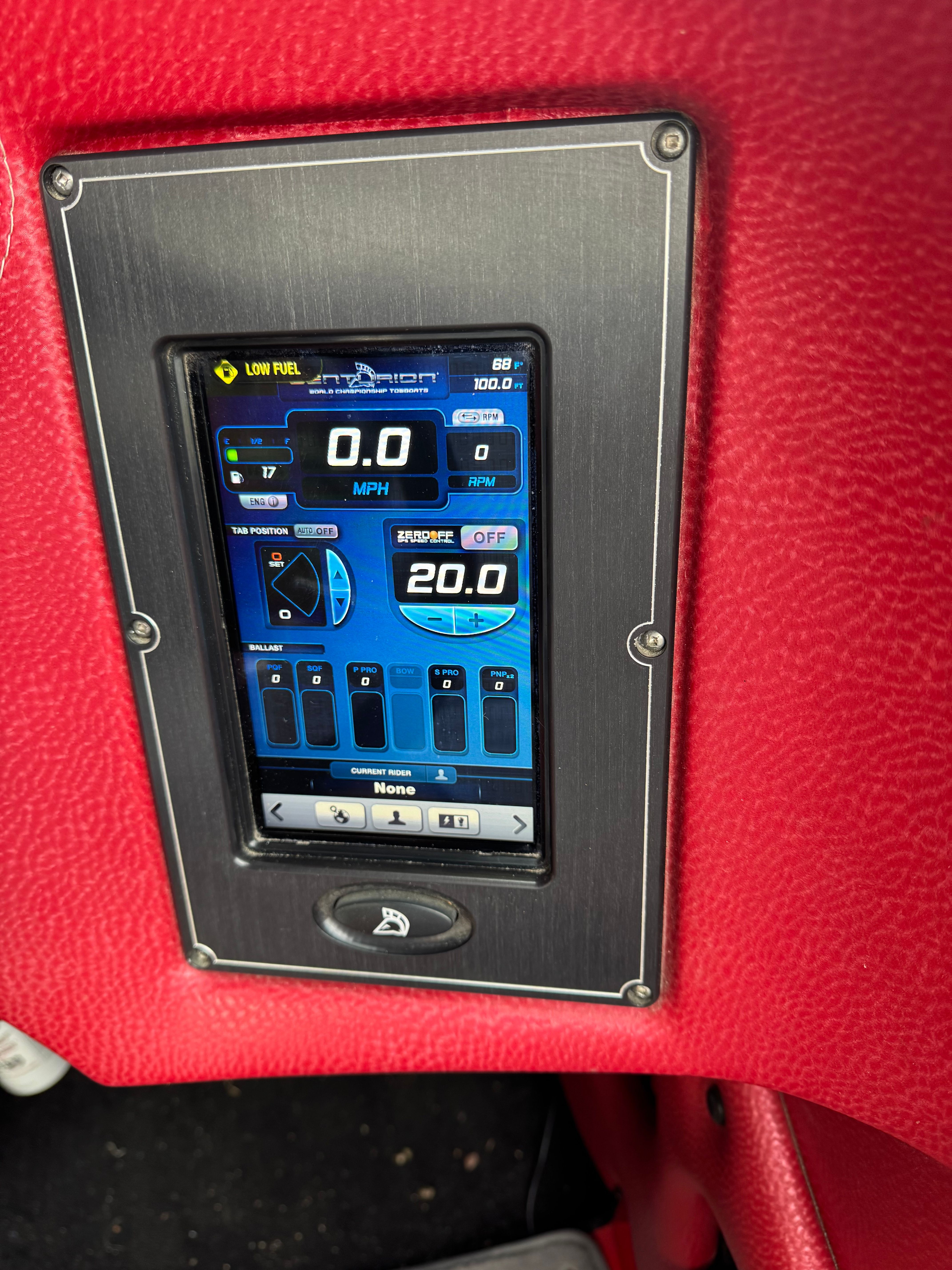 A digital dashboard displaying speed and other boat information, surrounded by red upholstery.