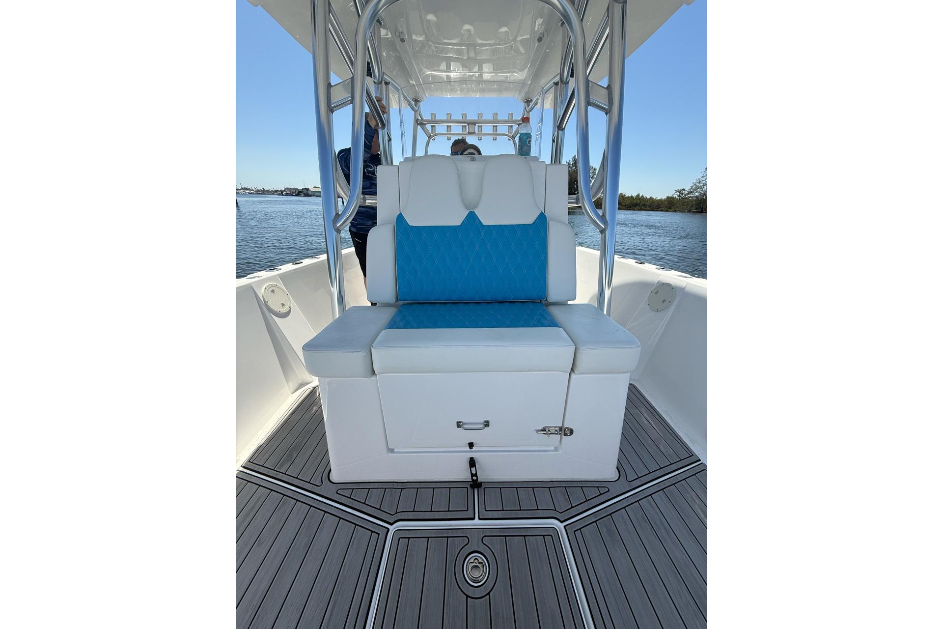 2021 Custom Infusion 34 CC boat interior with blue and white seating, on calm water.