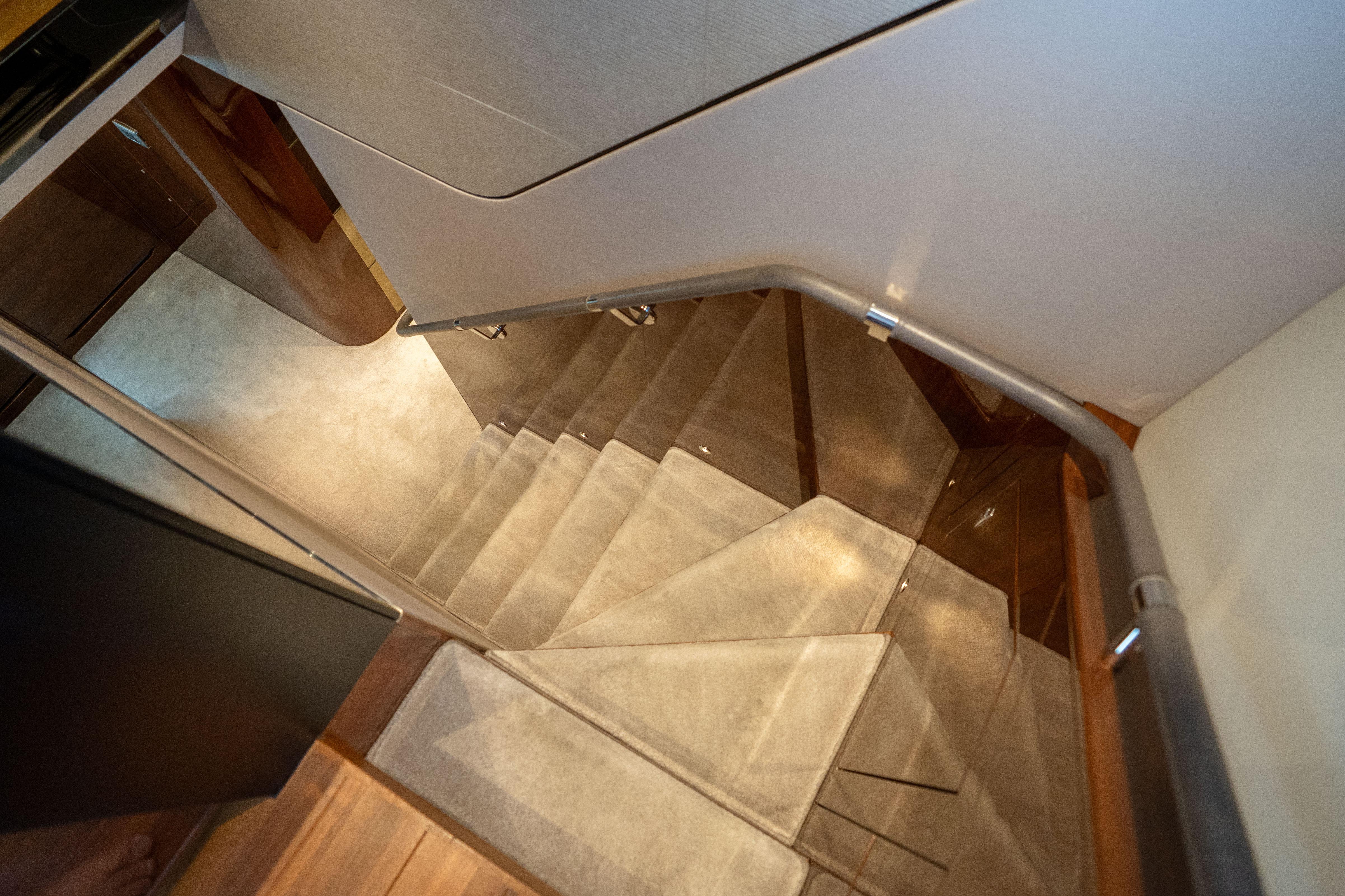 Luxurious interior staircase of 2020 Princess Y85 yacht, featuring elegant design and lighting.