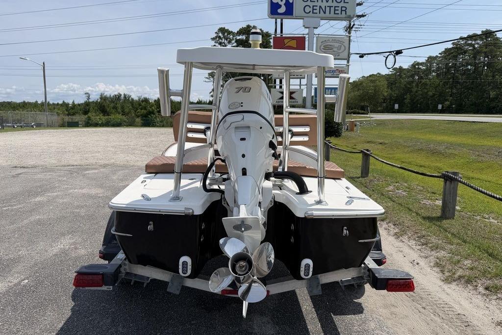 2012 Chaos 16 Bonefish boat with outboard motor, parked near service center.