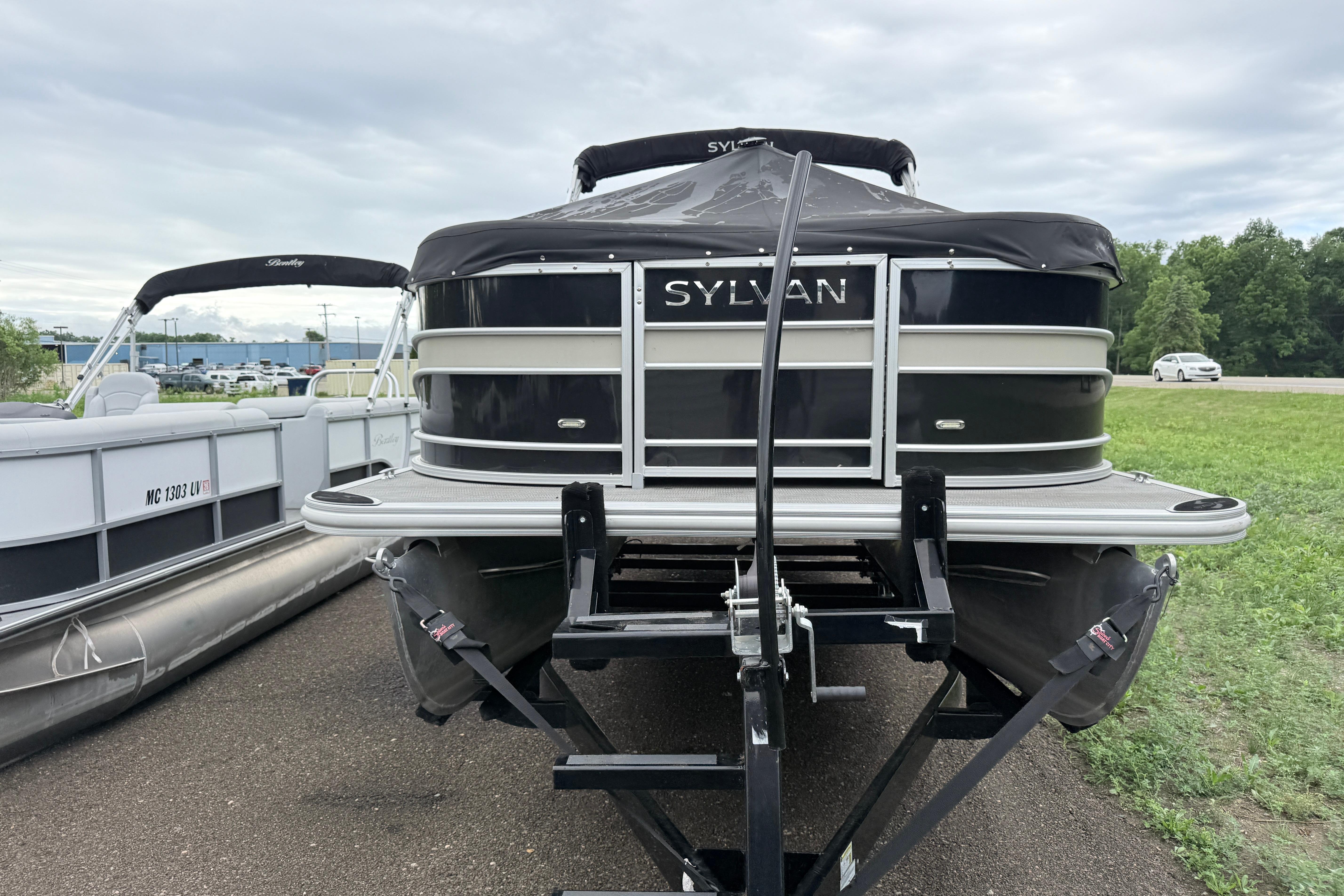 2019 Sylvan 8522 Mirage Signature pontoon boat on trailer, parked outdoors.