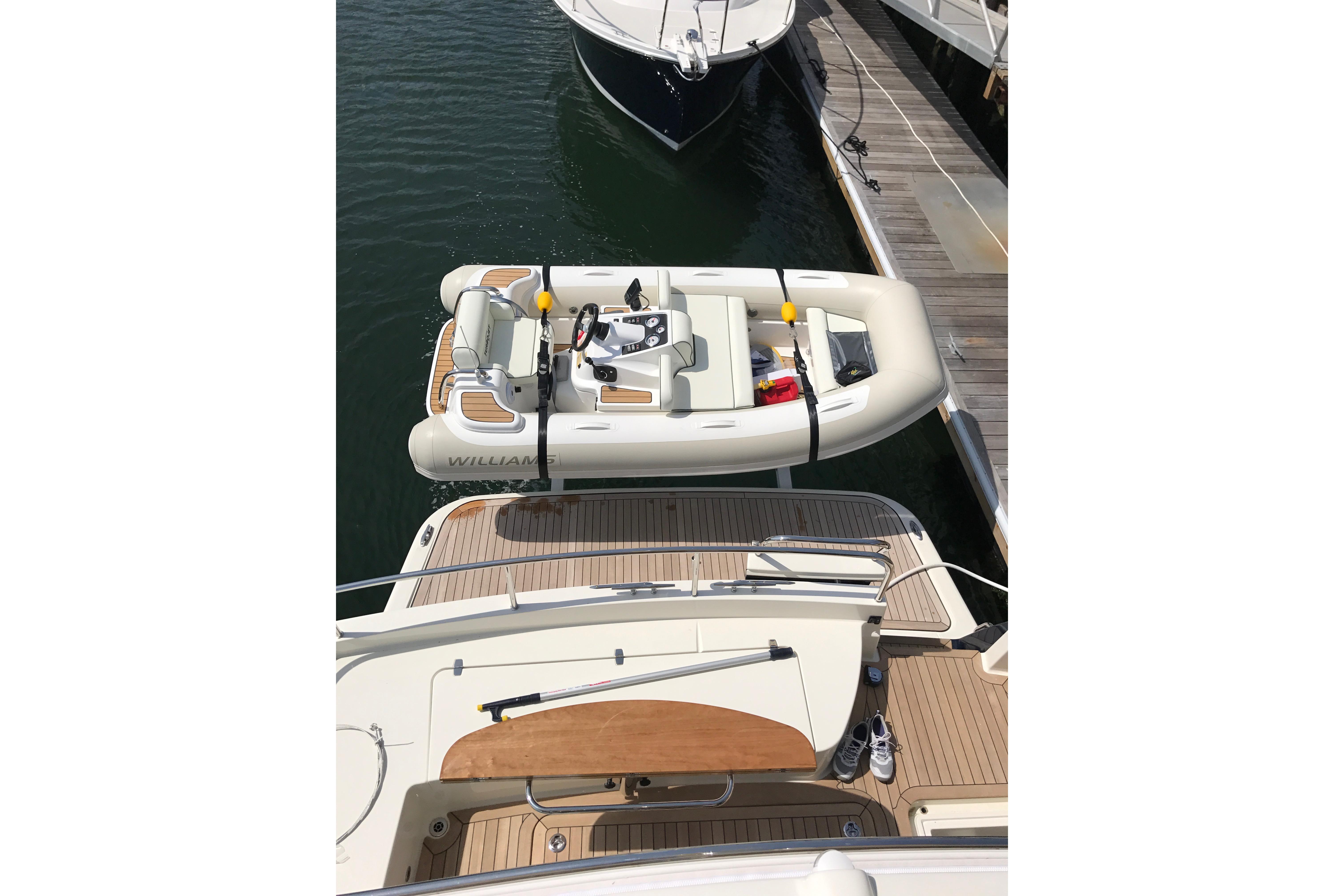 2017 Williams Jet Tenders Turbojet 325 docked beside a yacht, viewed from above.