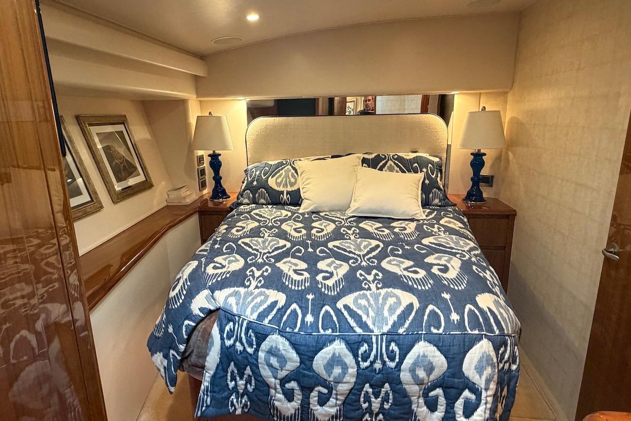 Luxurious bedroom interior of 2012 Viking 50 Convertible yacht with elegant decor and bedding.