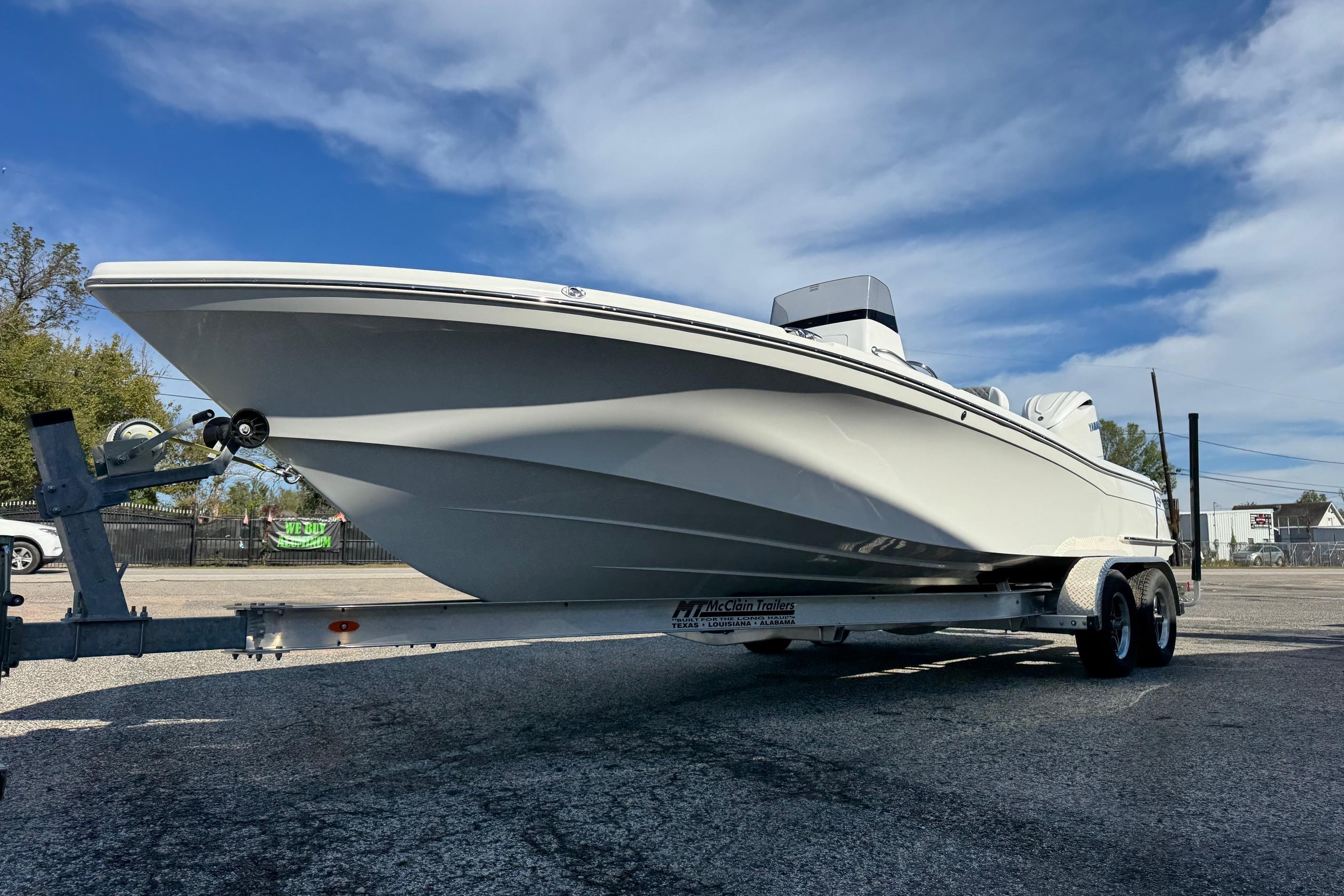 2026 BlackJack 256 Bay boat on trailer under clear blue sky.