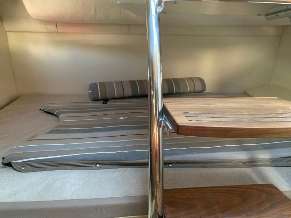 Interior of a 2017 Regal 26 Express with striped upholstery and a wooden table.