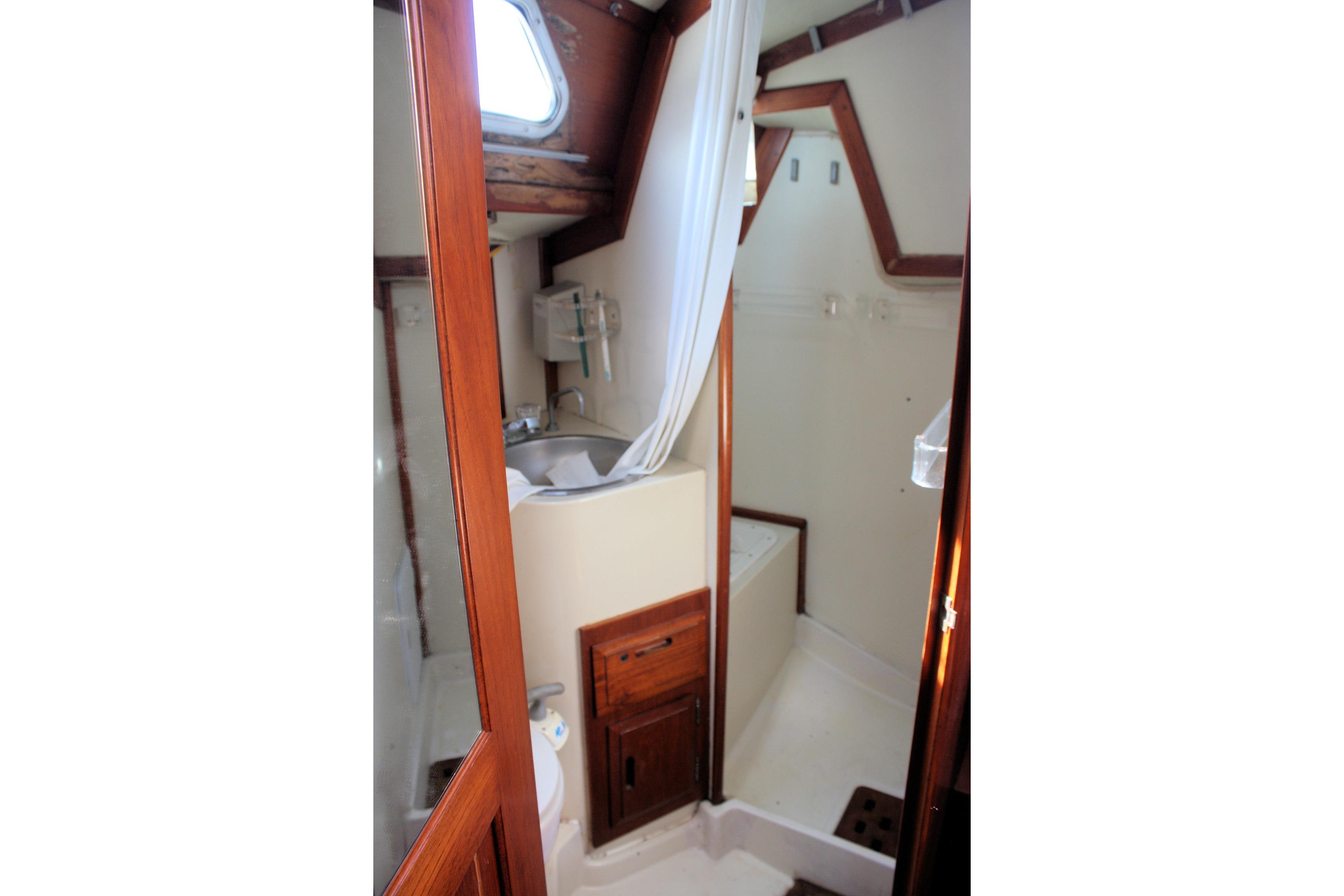 Interior of 1987 Ericson 38-200 sailboat bathroom with wooden accents and compact design.