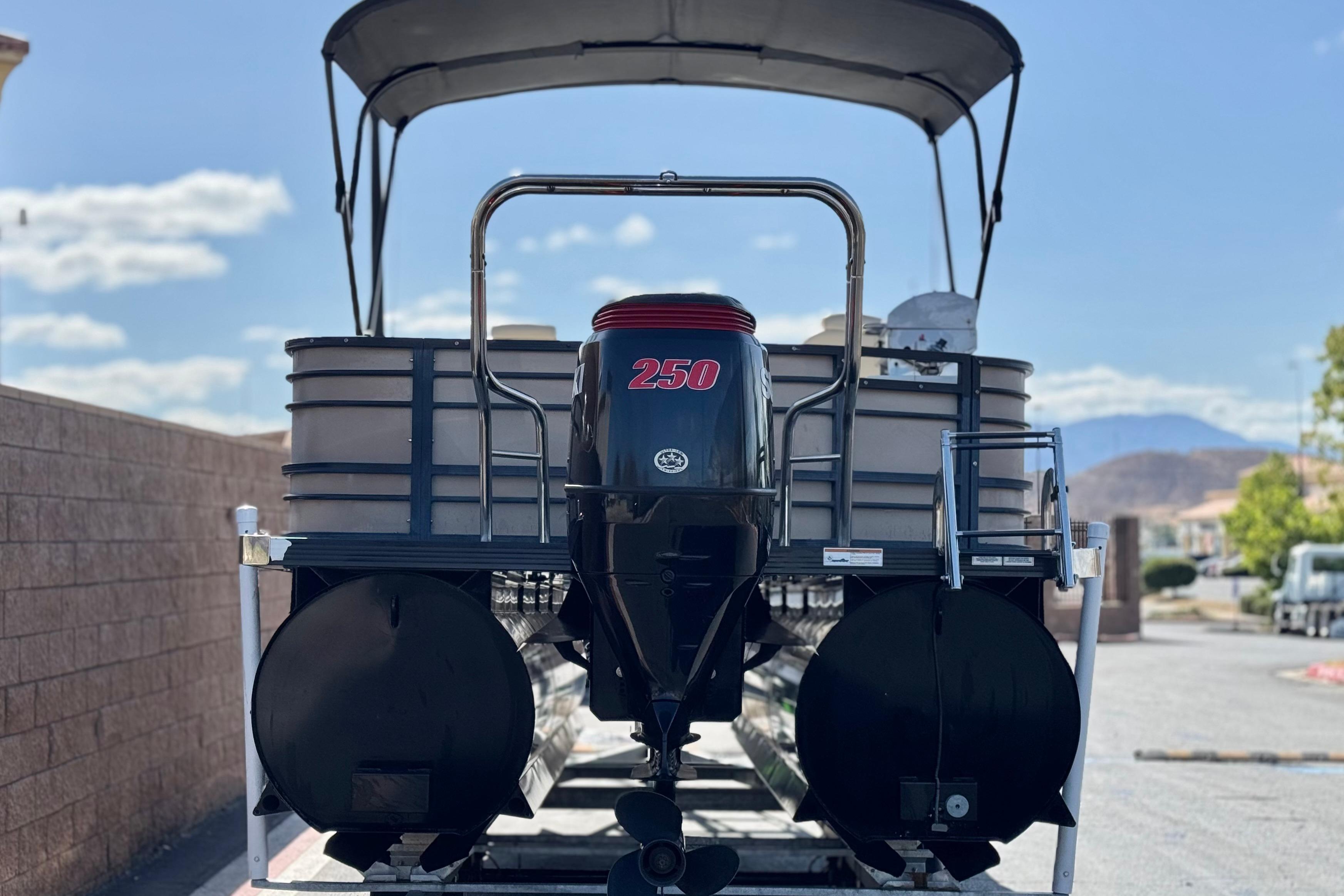 2023 Lexington 623 ST Xtreme pontoon boat with powerful 250 HP engine, parked outdoors.