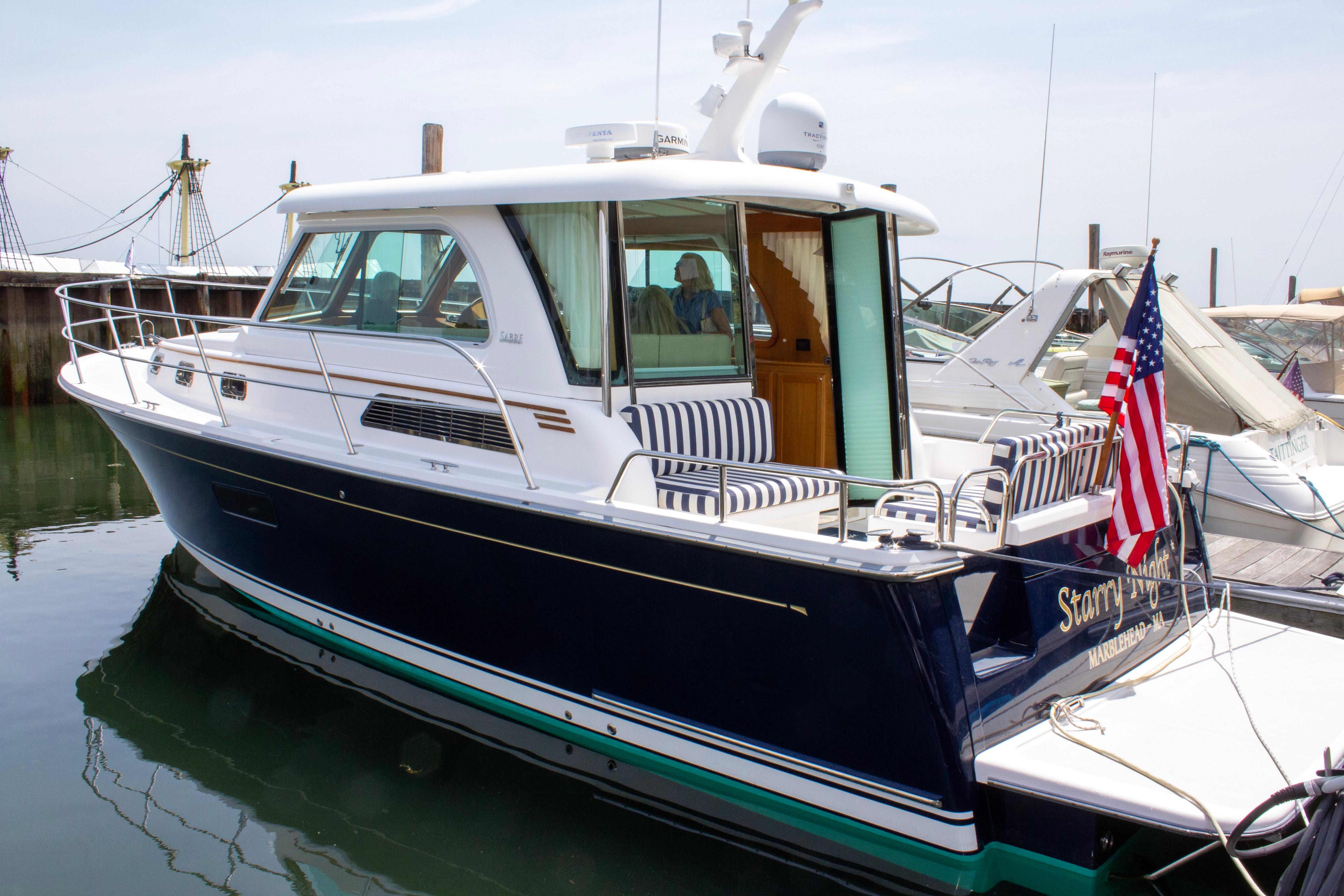 2013 Sabre 38 Salon Express yacht docked, featuring sleek design and American flag.