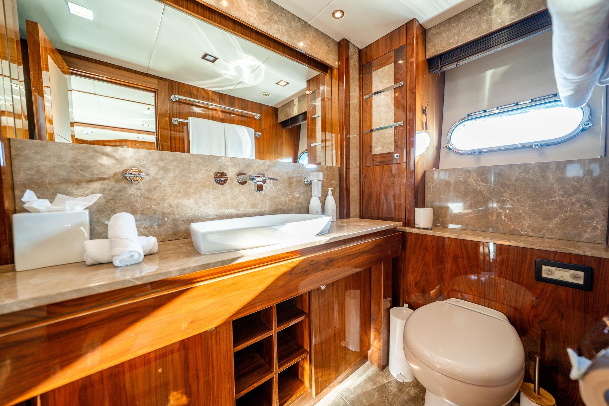 Luxurious bathroom in 2010 Sunseeker 30M yacht with elegant wood and marble finishes.