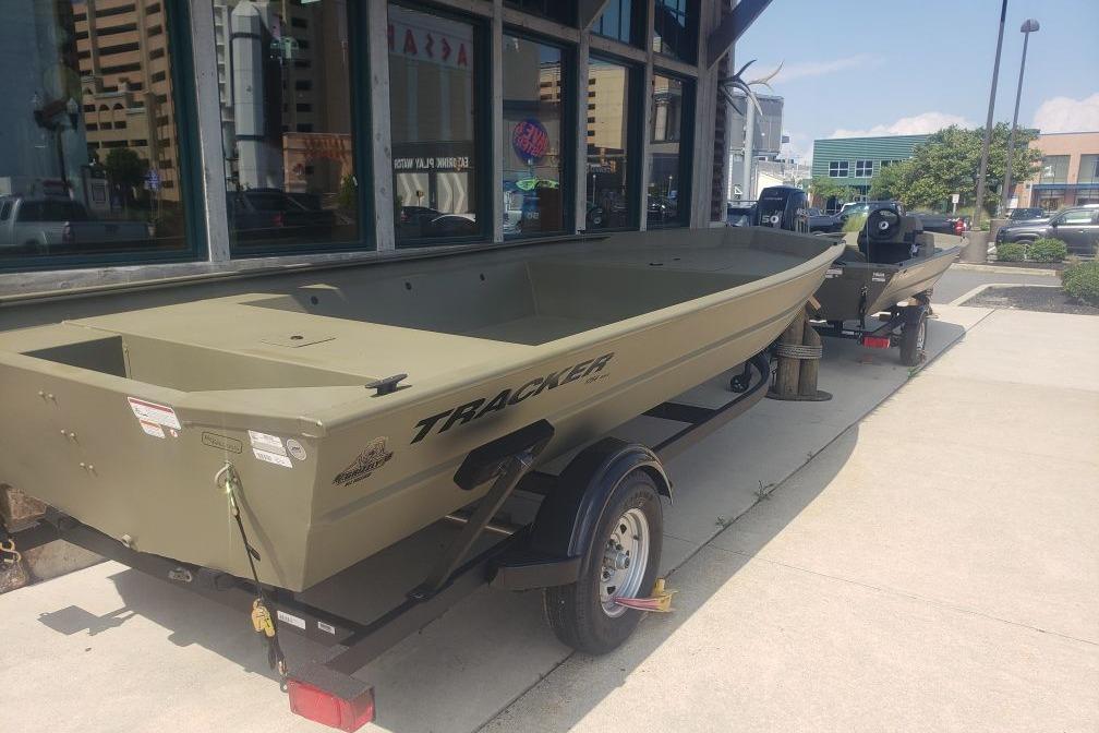 2026 Tracker Grizzly 1754 Utility boat on trailer, parked outside a building.